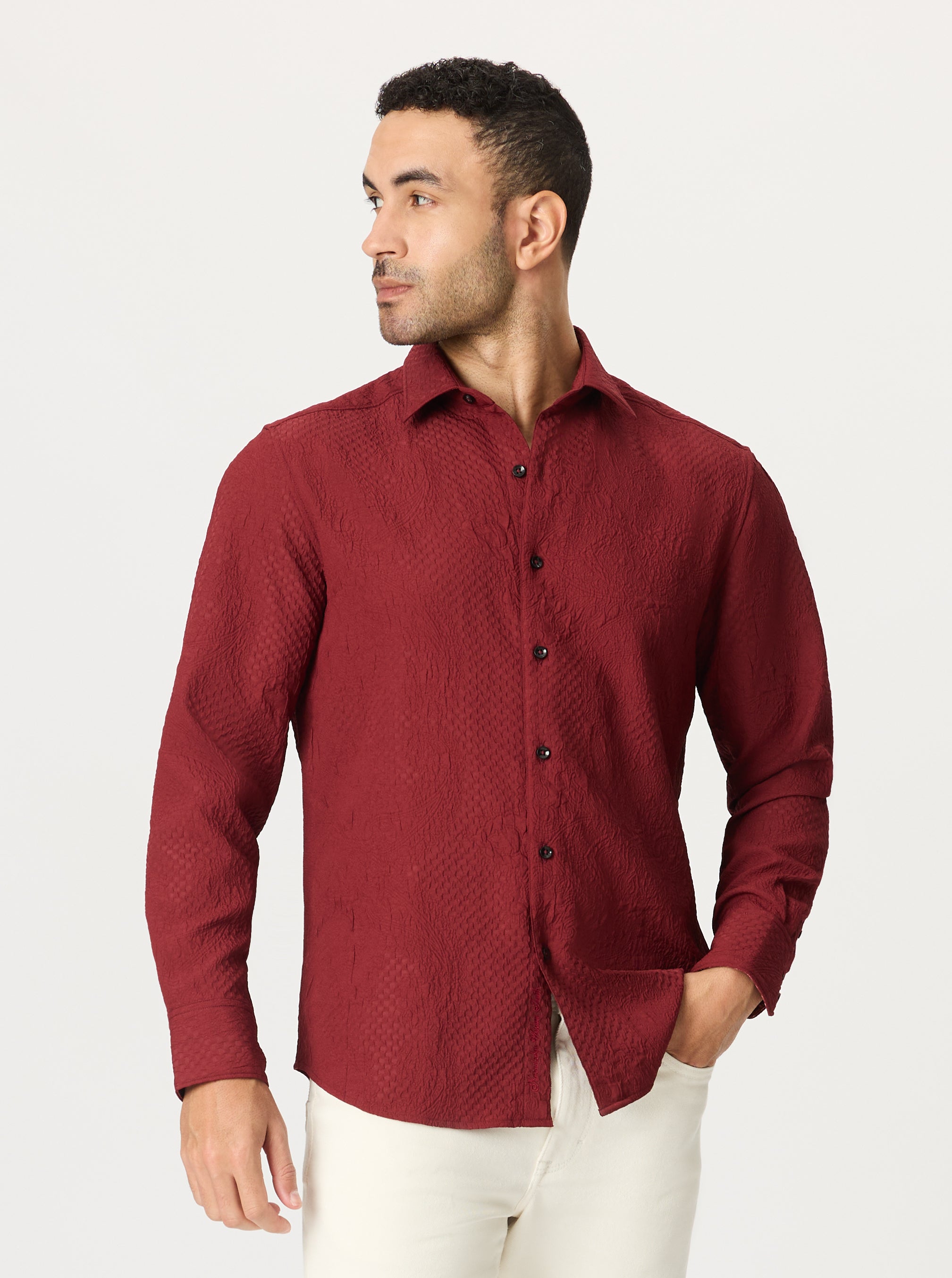 Man wearing a red patterned and textured shirt on a white background