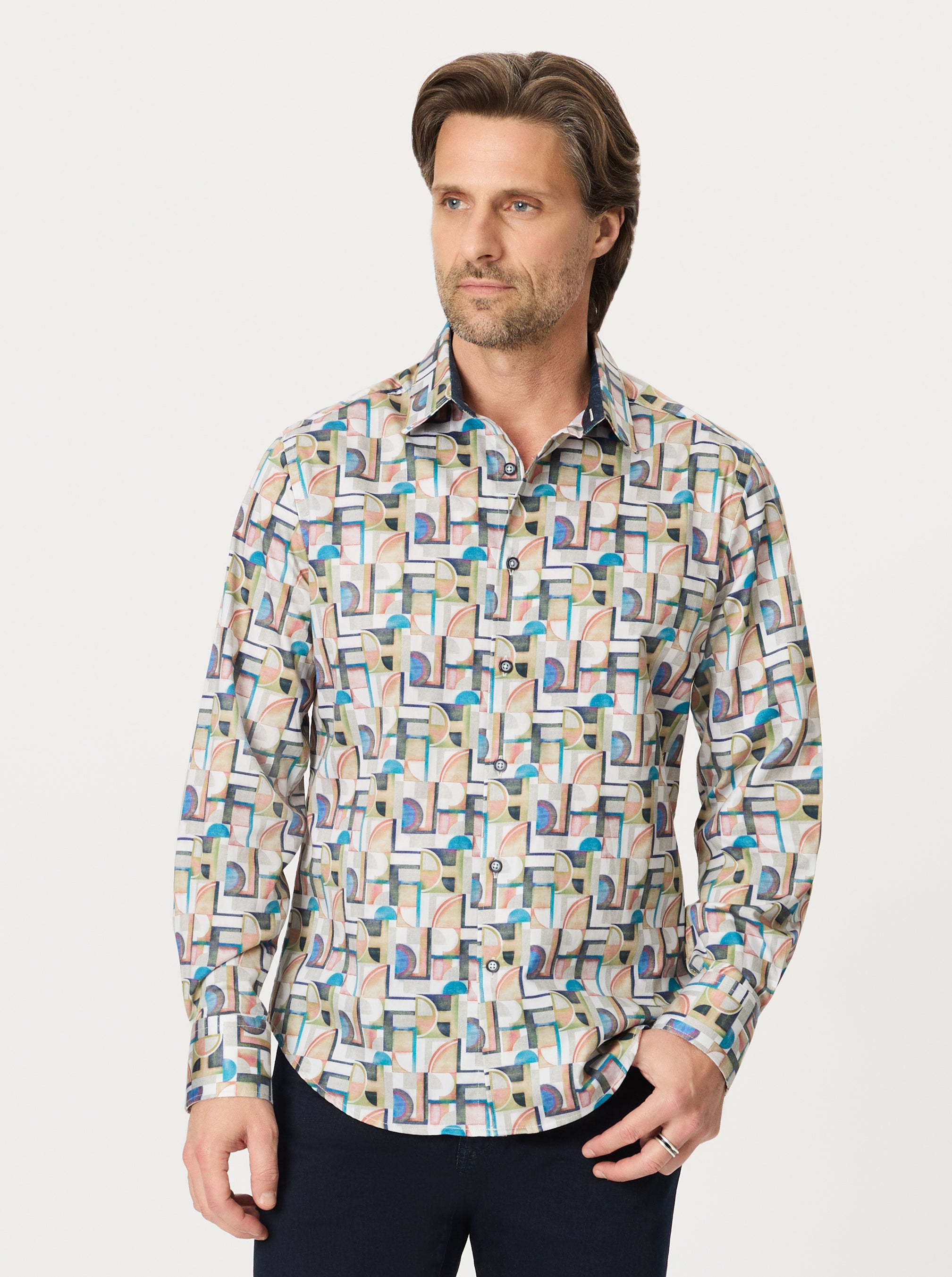Man wearing a patterned shirt on a plain background