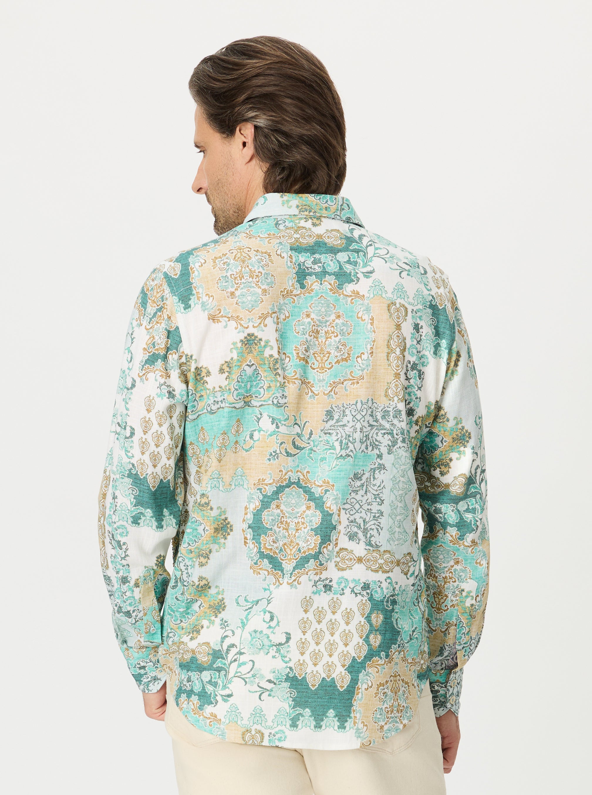 Man wearing a scroll patterned shirt with a white background