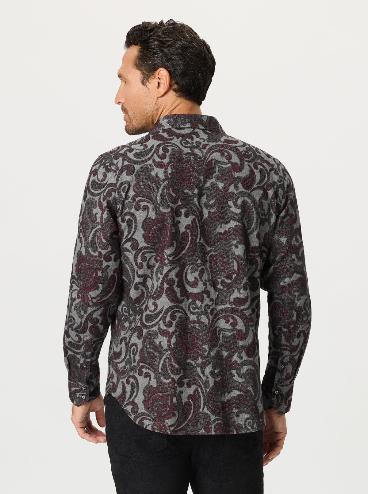 Man wearing a grey paisley patterned shirt on a white background