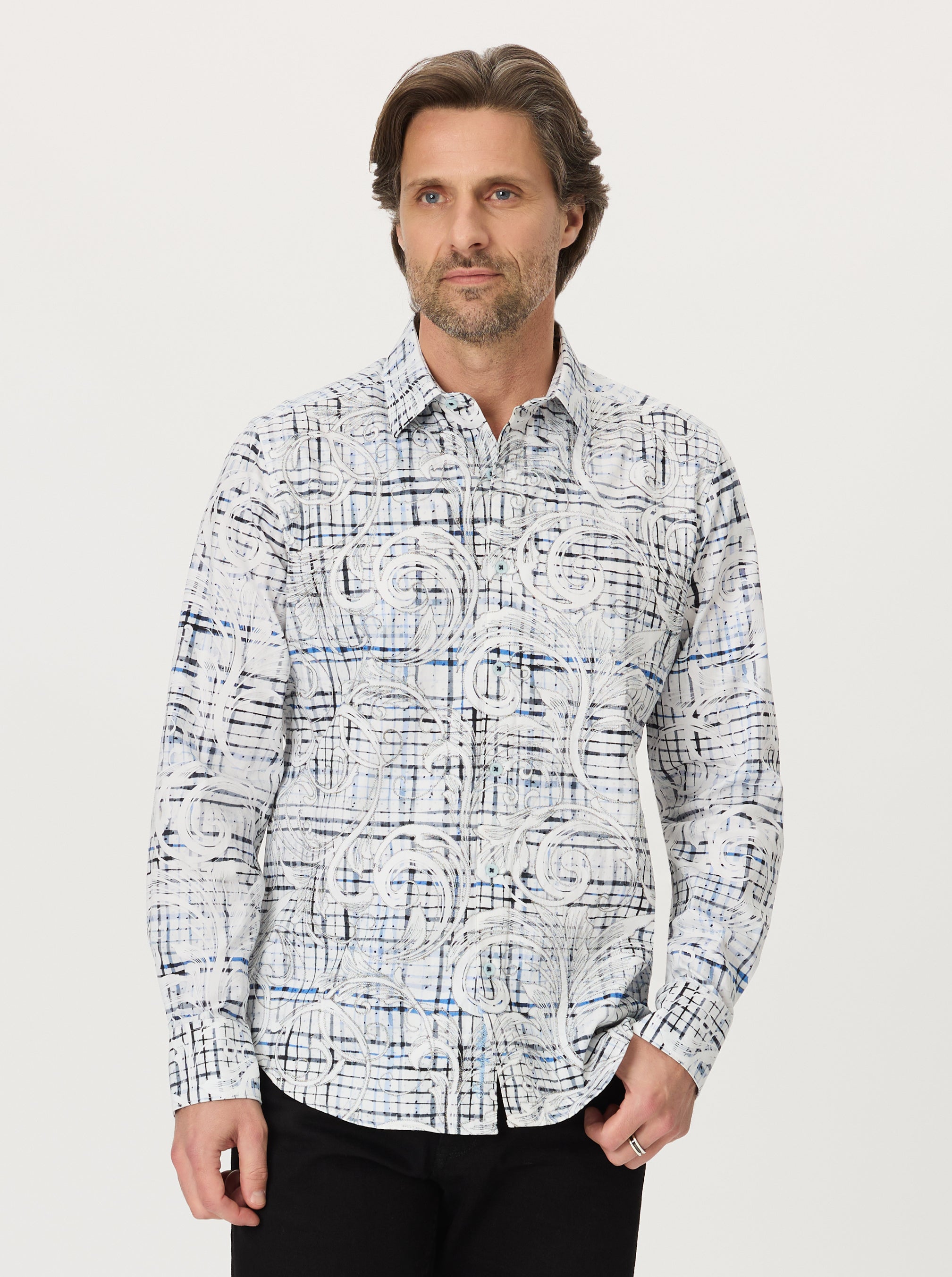 Man wearing a plaid and paisley patterned shirt against a plain background