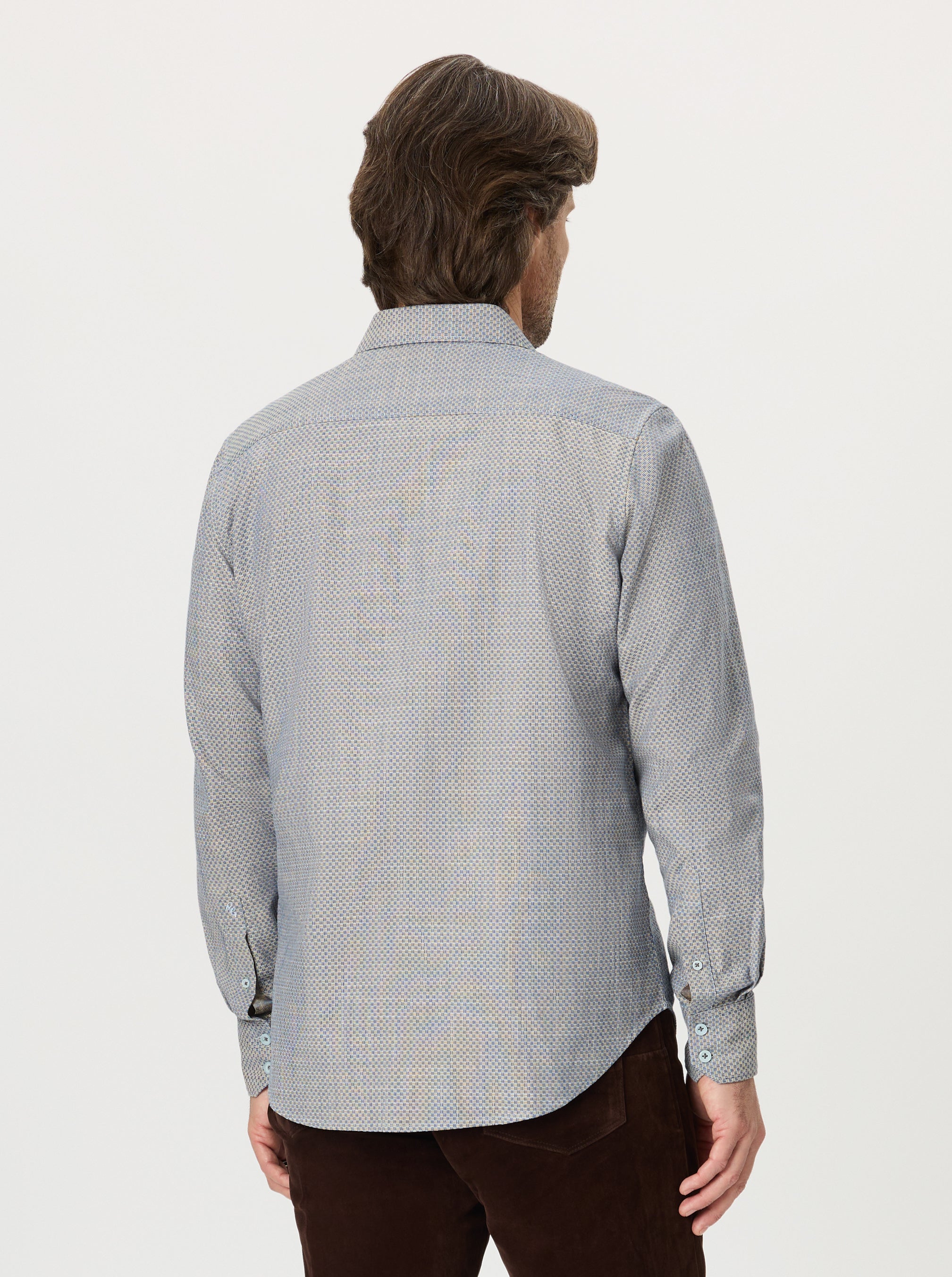 Person wearing a light blue patterned shirt on a white background