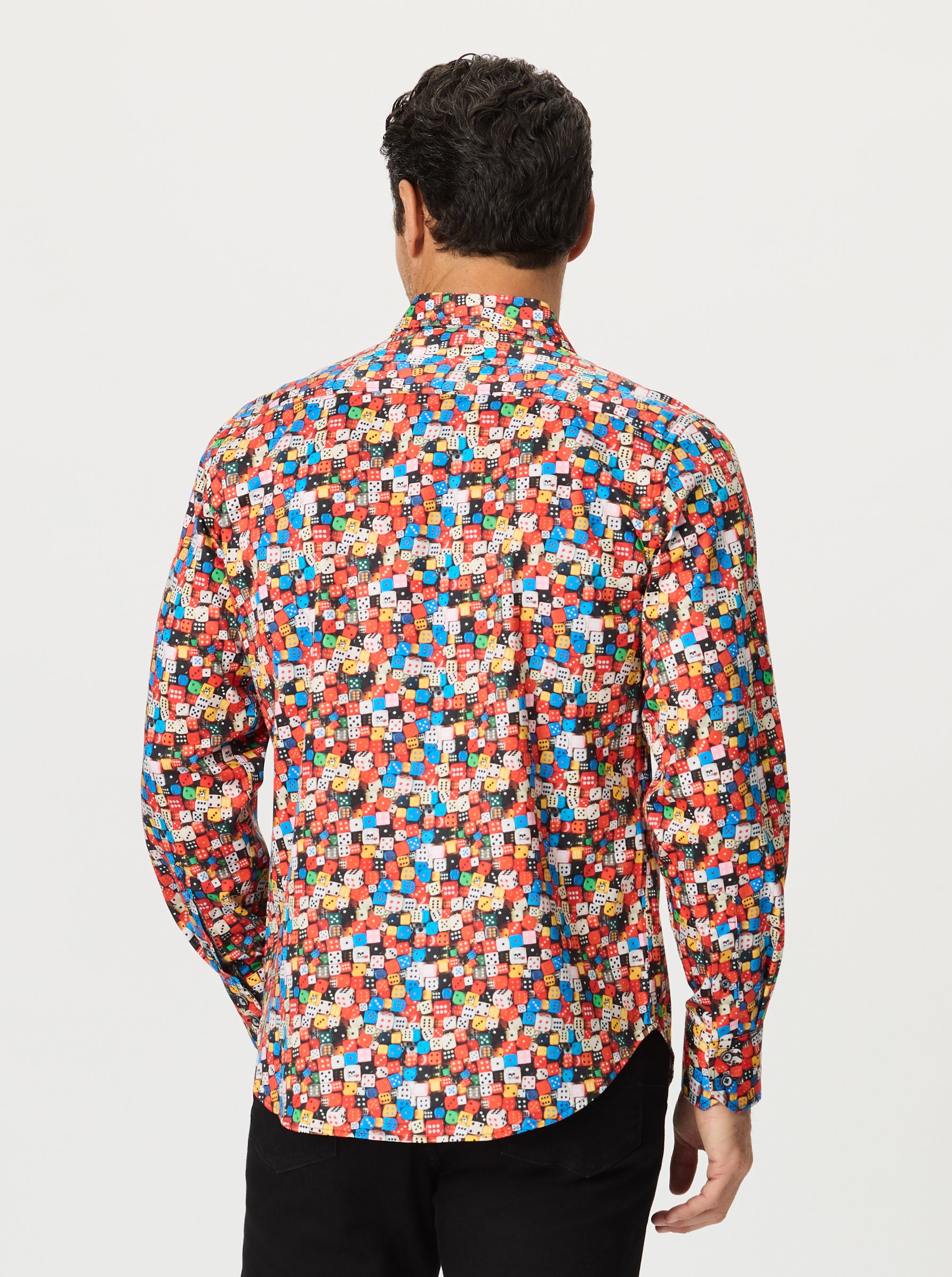 Man wearing a colorful patterned shirt on a plain background