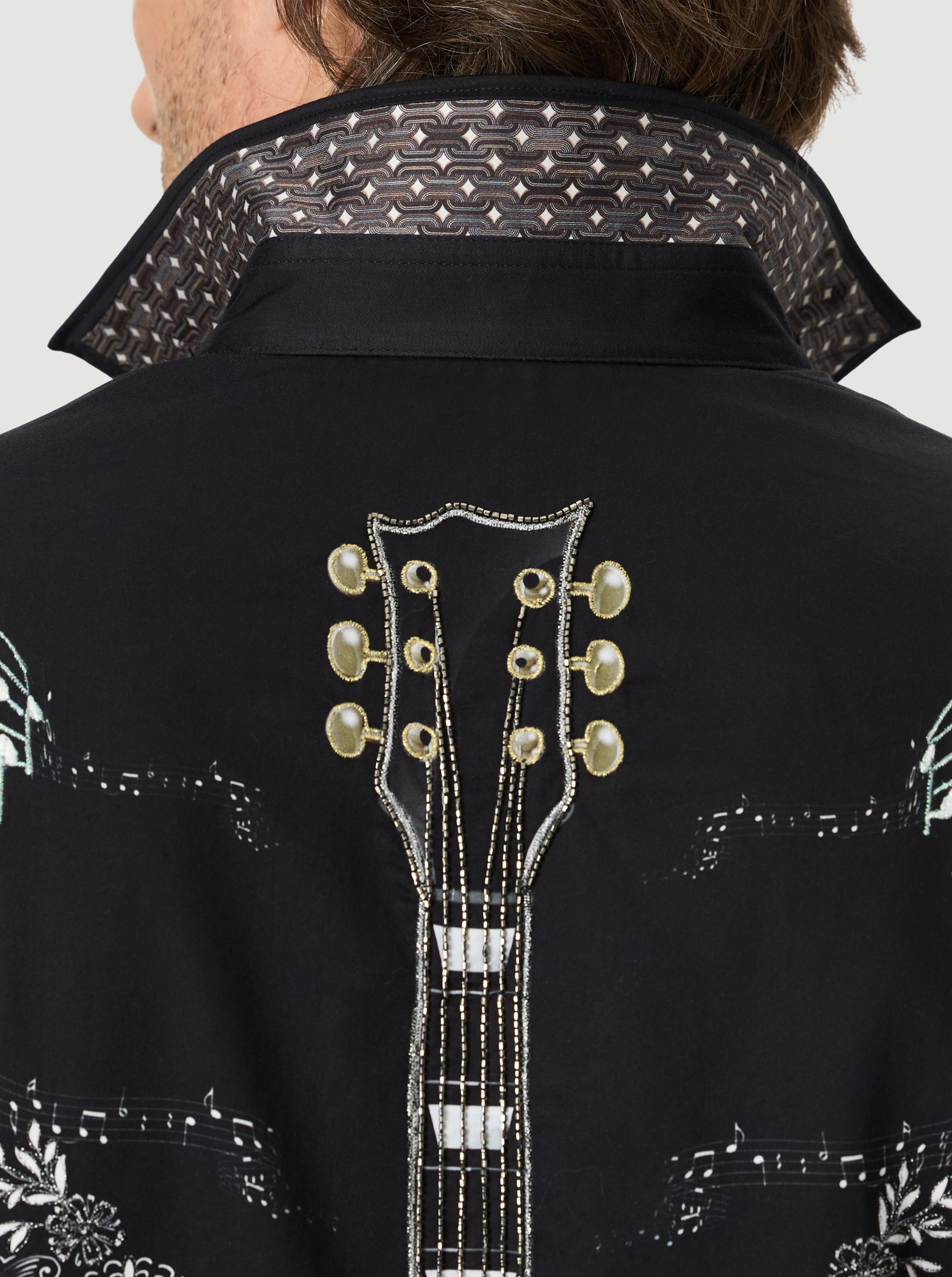 Black embroidered jacket with guitar design on a white background