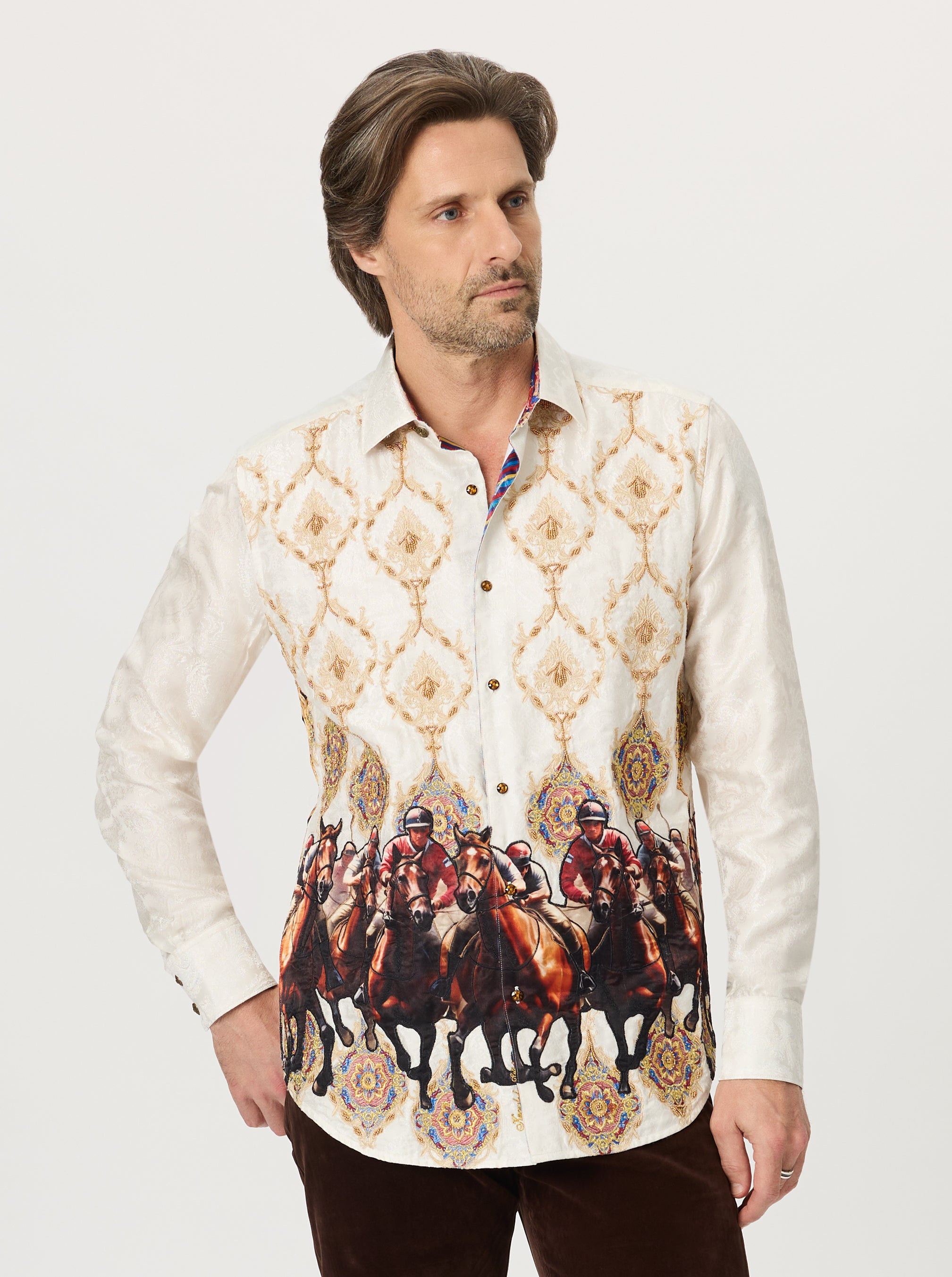 Man wearing a patterned shirt with horse and rider design on a plain background