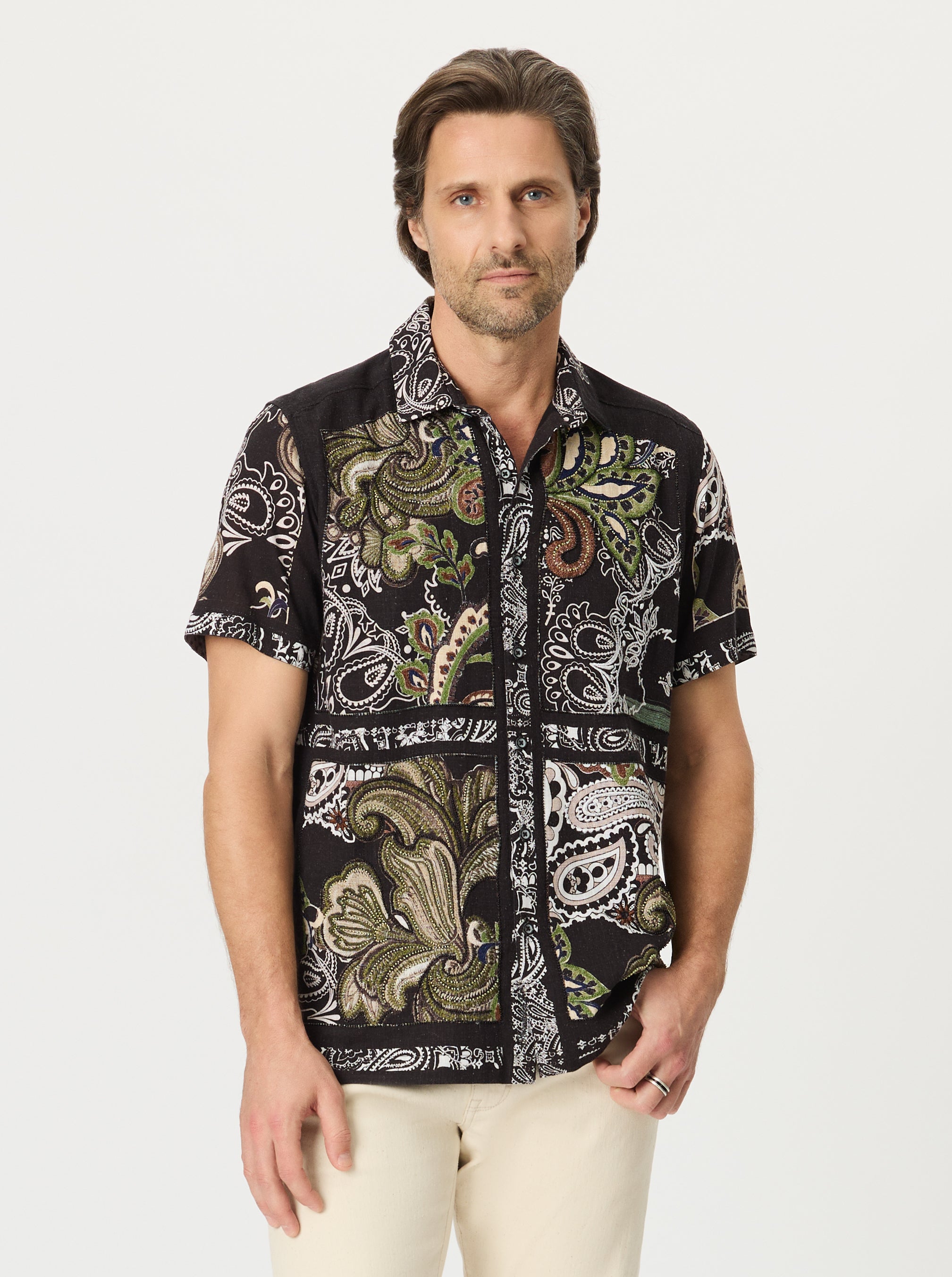 Man wearing a scroll patterned black shirt with a white background