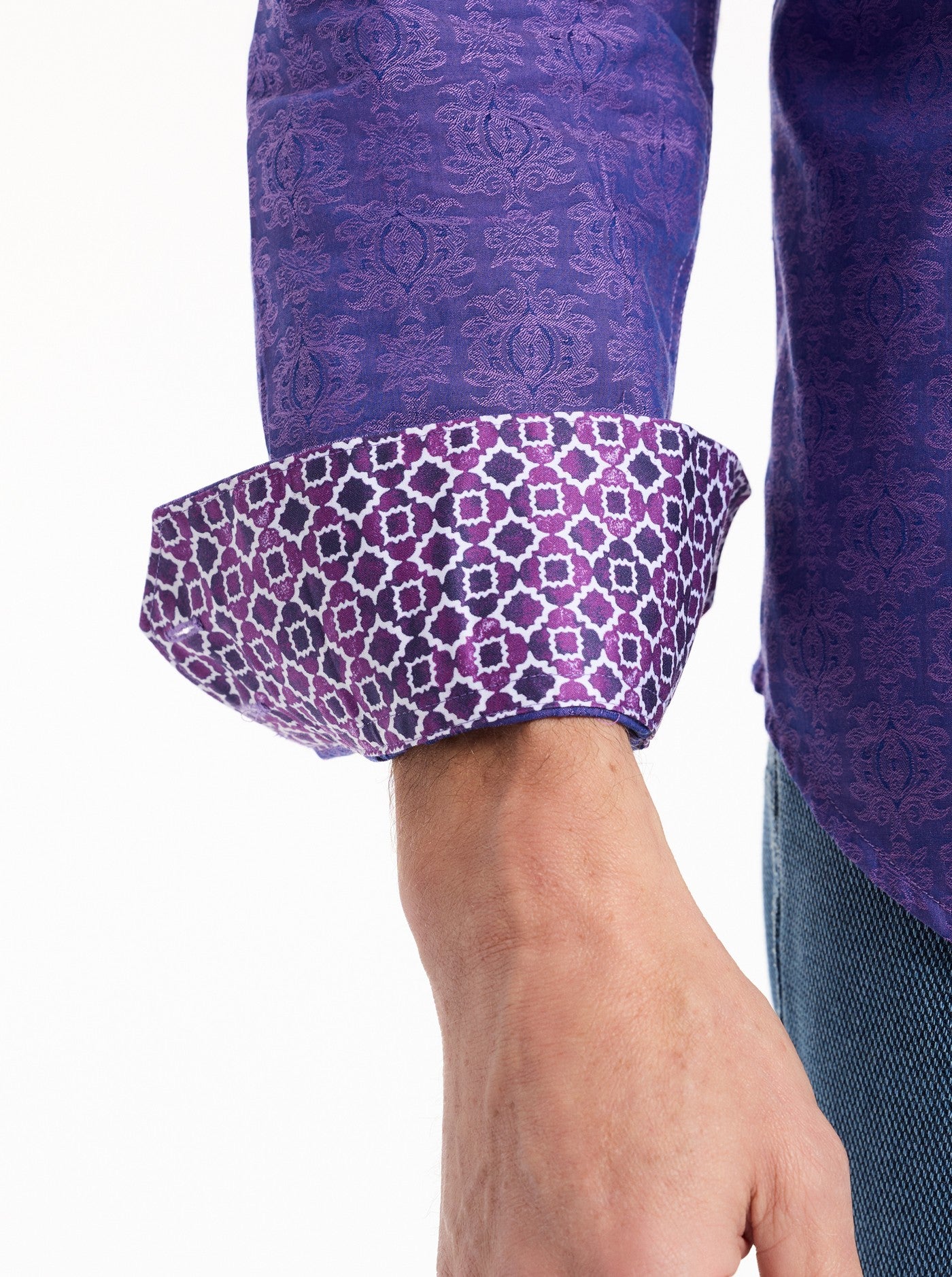 Close-up of a person wearing a purple patterned shirt with rolled-up sleeves on a white background