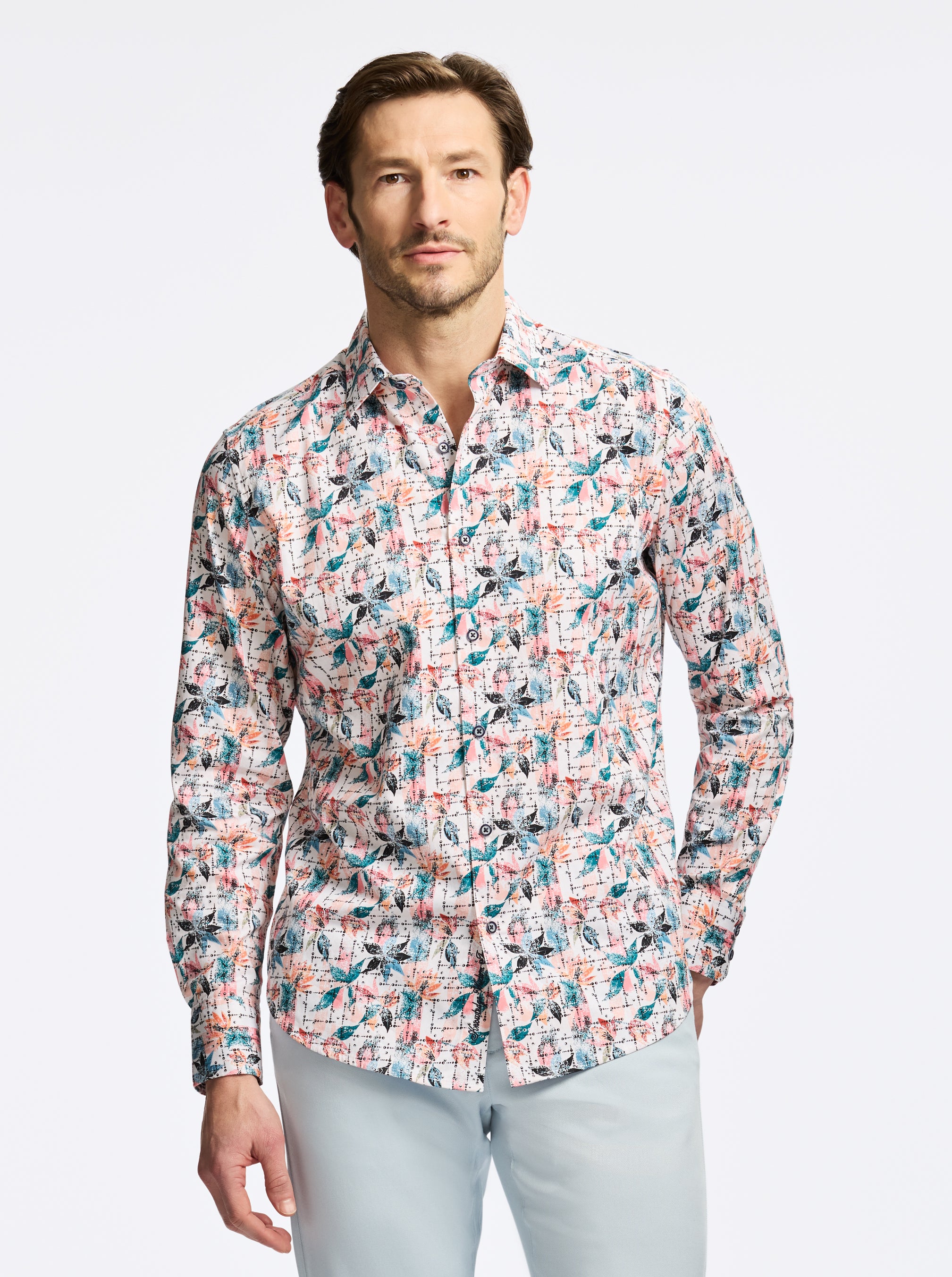 Man wearing a colorful patterned shirt on a light gray background