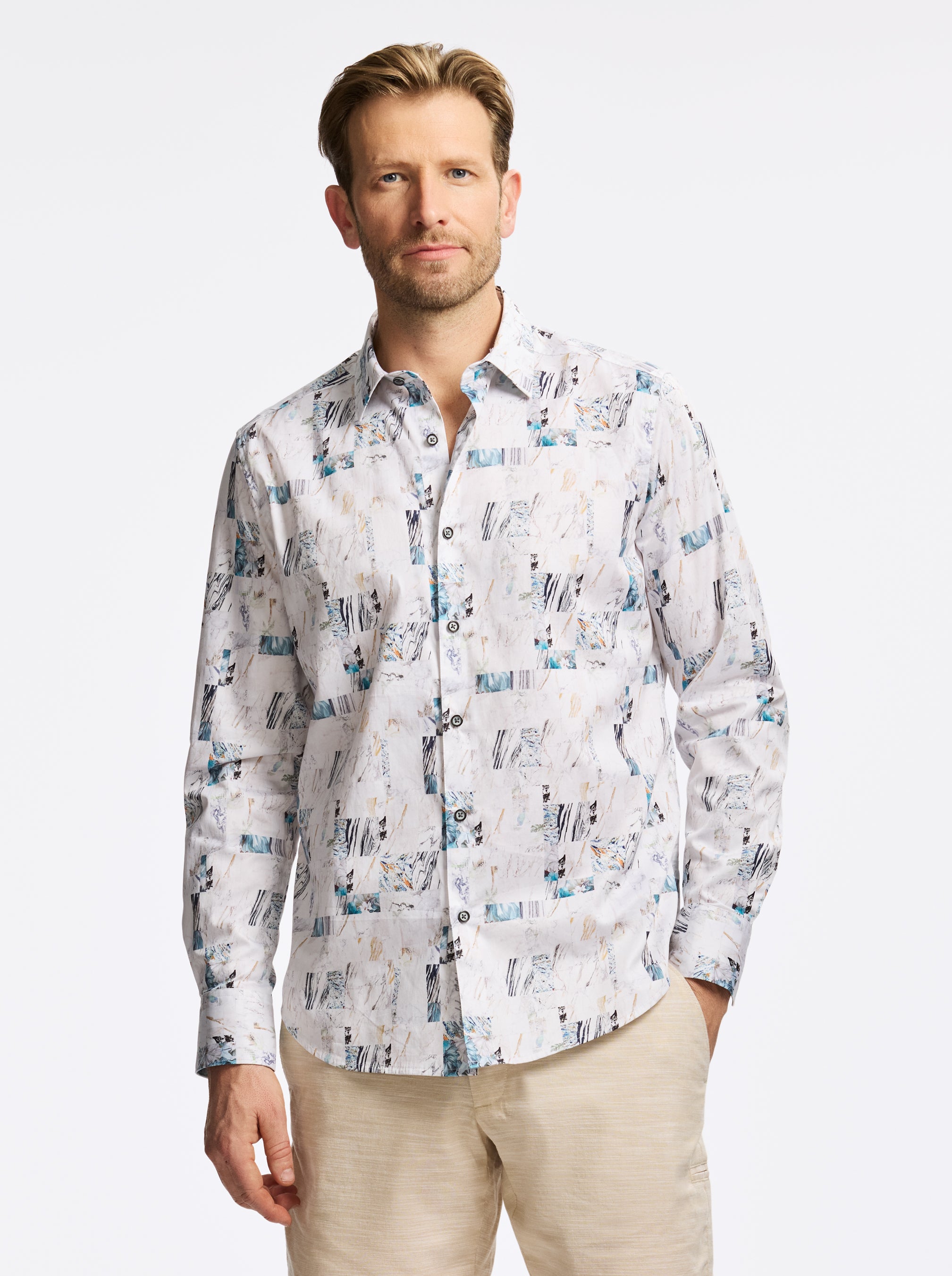 Man wearing a patterned shirt on a plain background