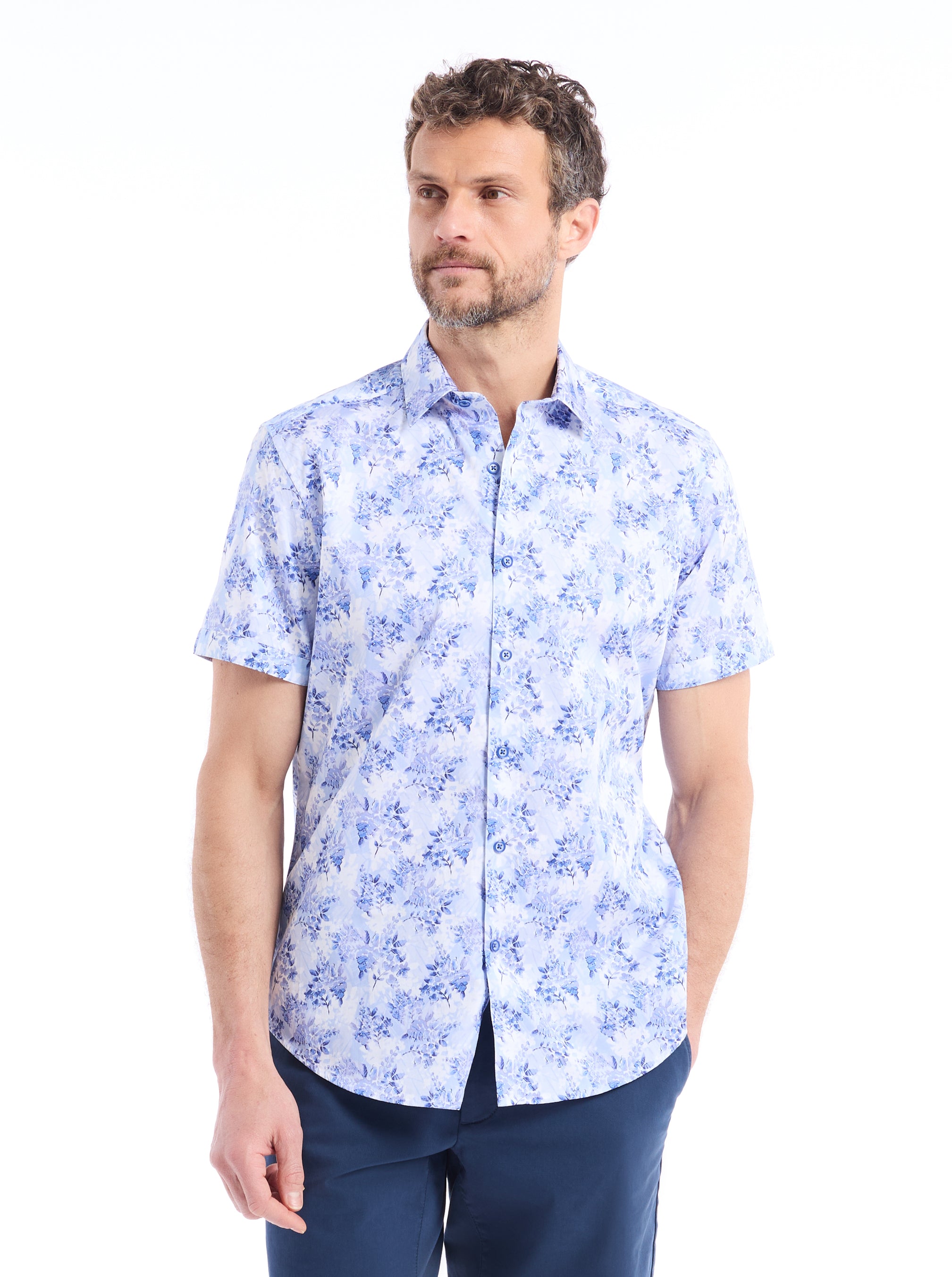 Man wearing a blue floral shirt on a white background