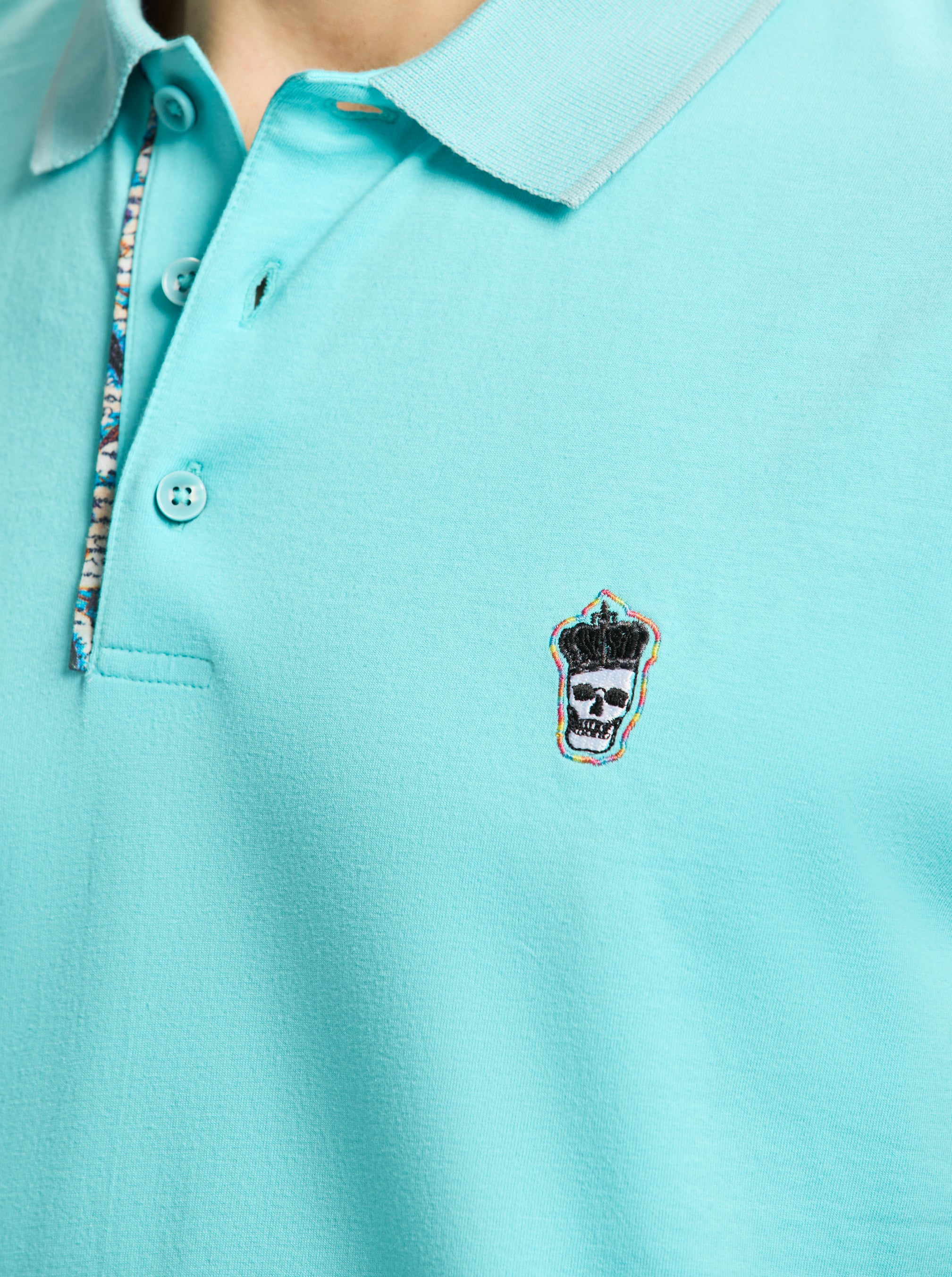 Close-up of a light blue polo shirt with a small logo on the chest.