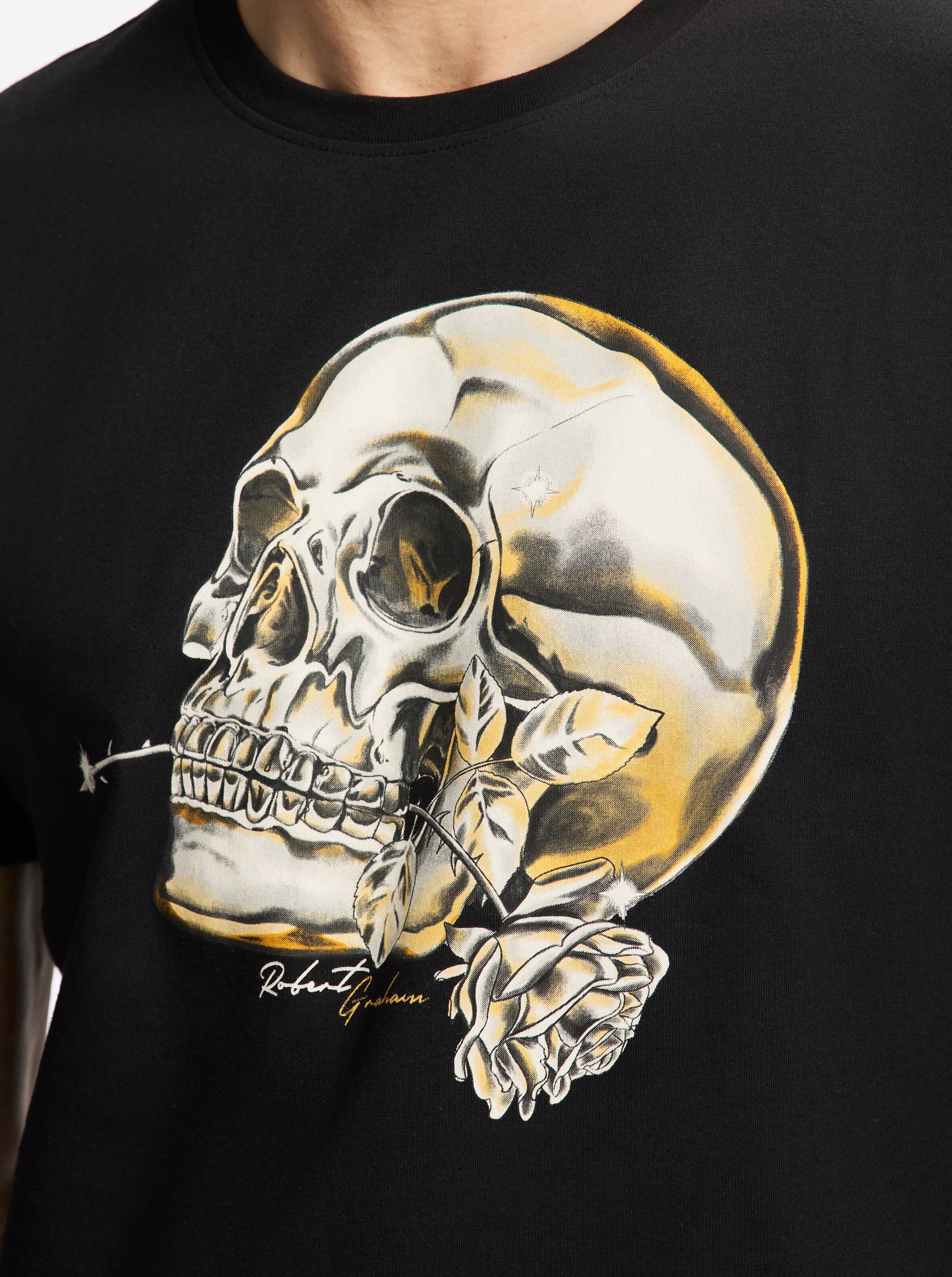 Black t-shirt with a graphic of a skull and roses on a dark background