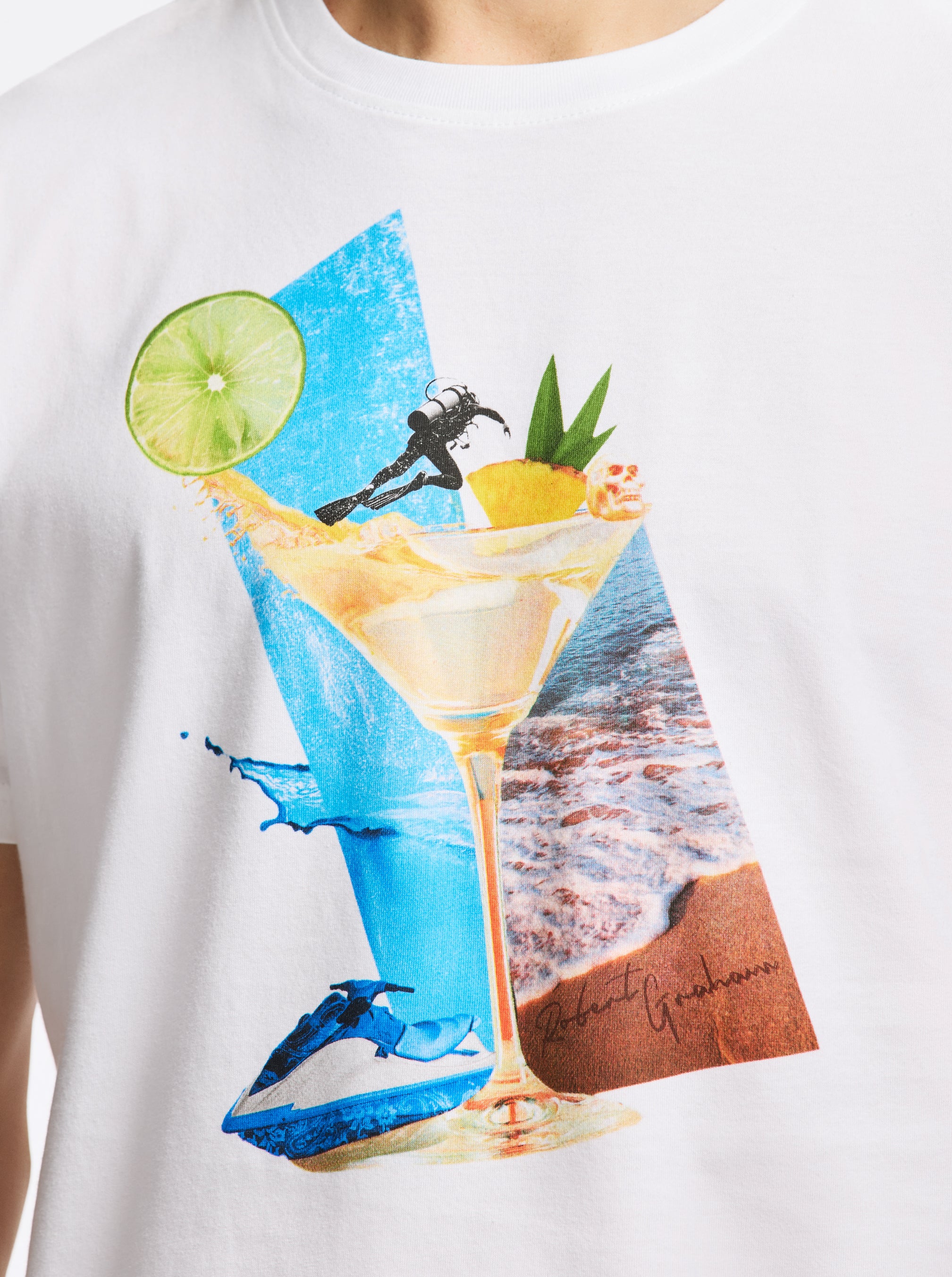 White t-shirt with a colorful graphic of a cocktail, beach scene, and jetskis.