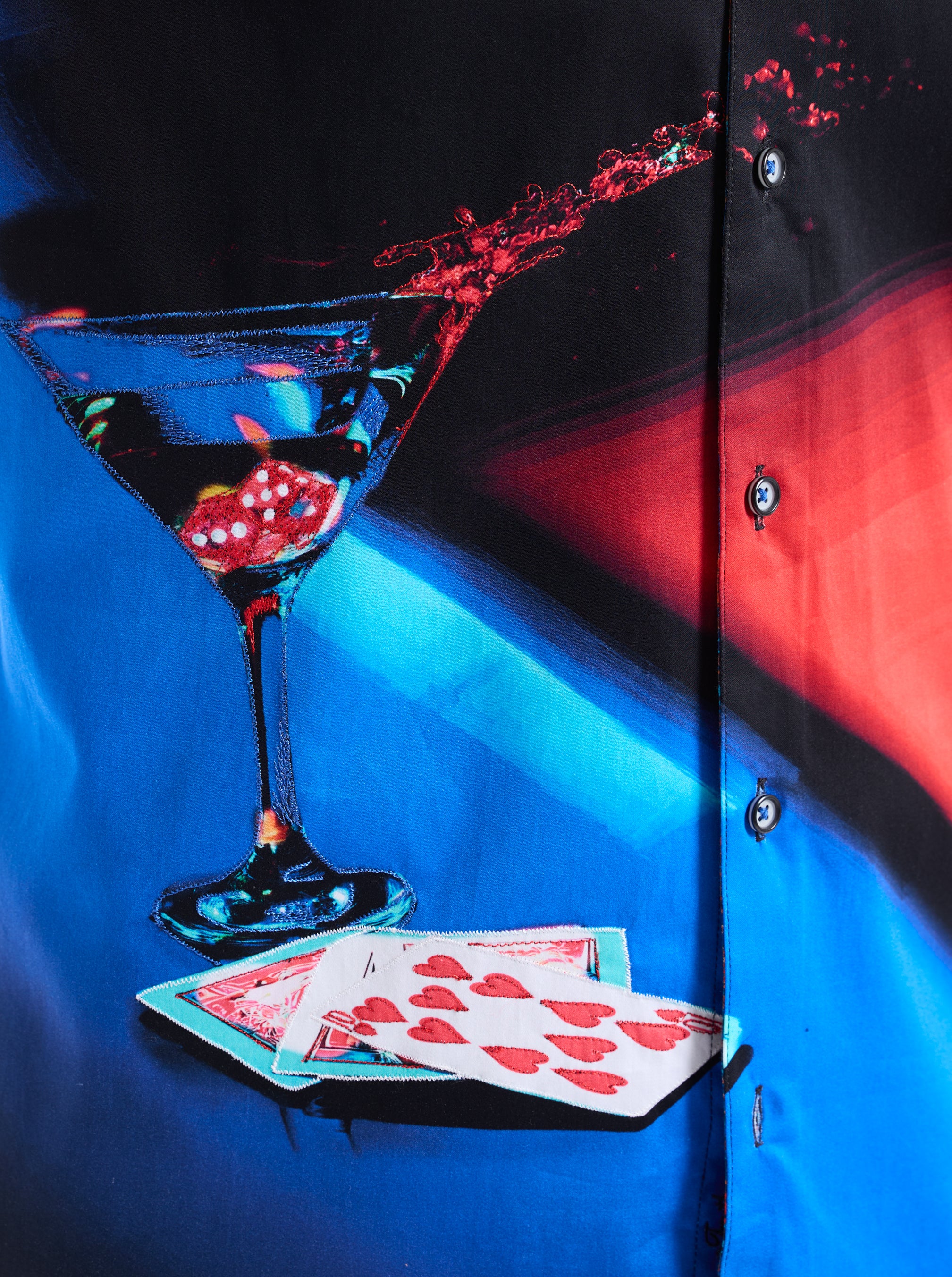 Shirt with a graphic of a martini glass and playing cards on a blue background