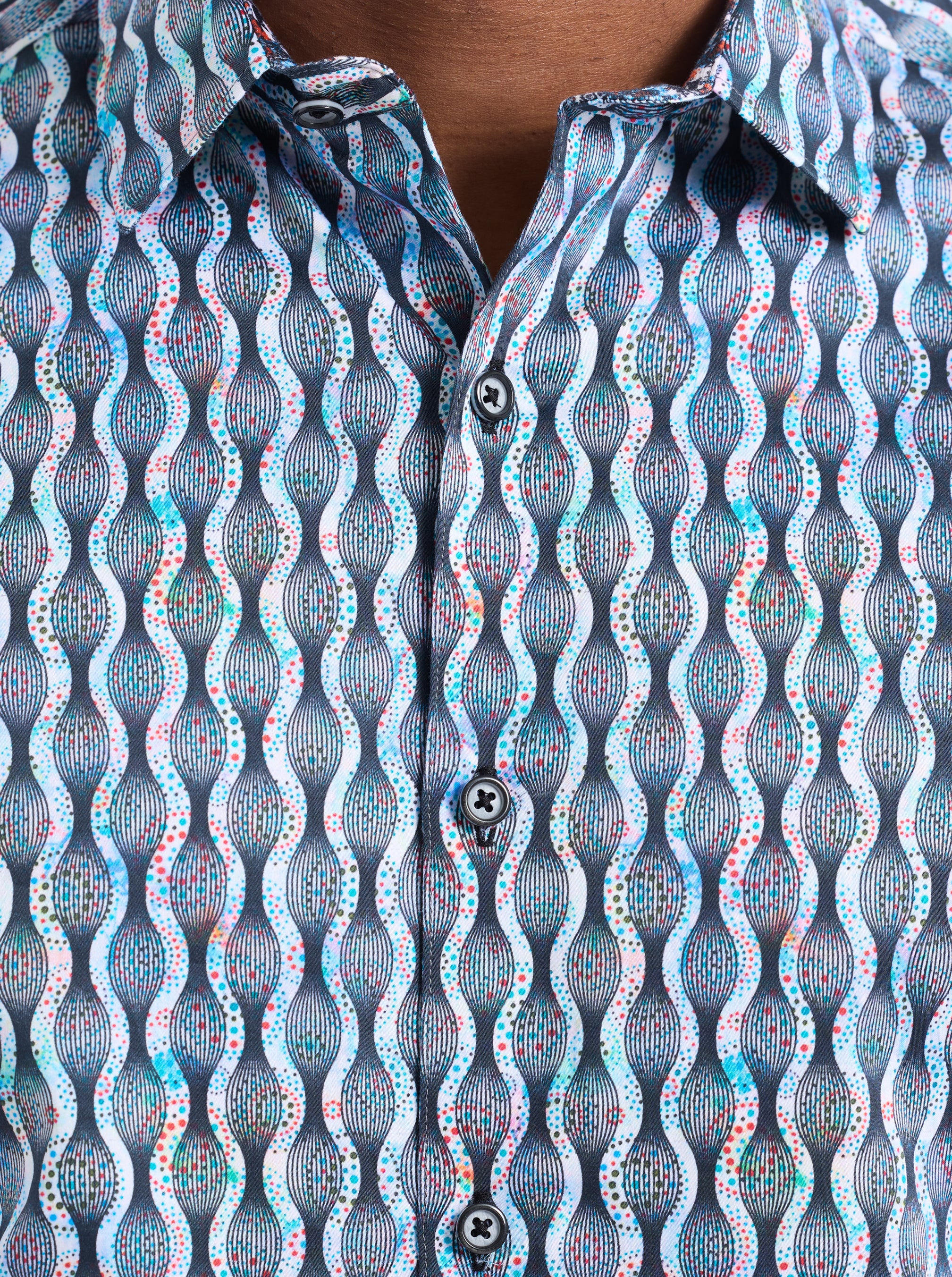 Close-up of a patterned shirt with wavy lines and small dots.