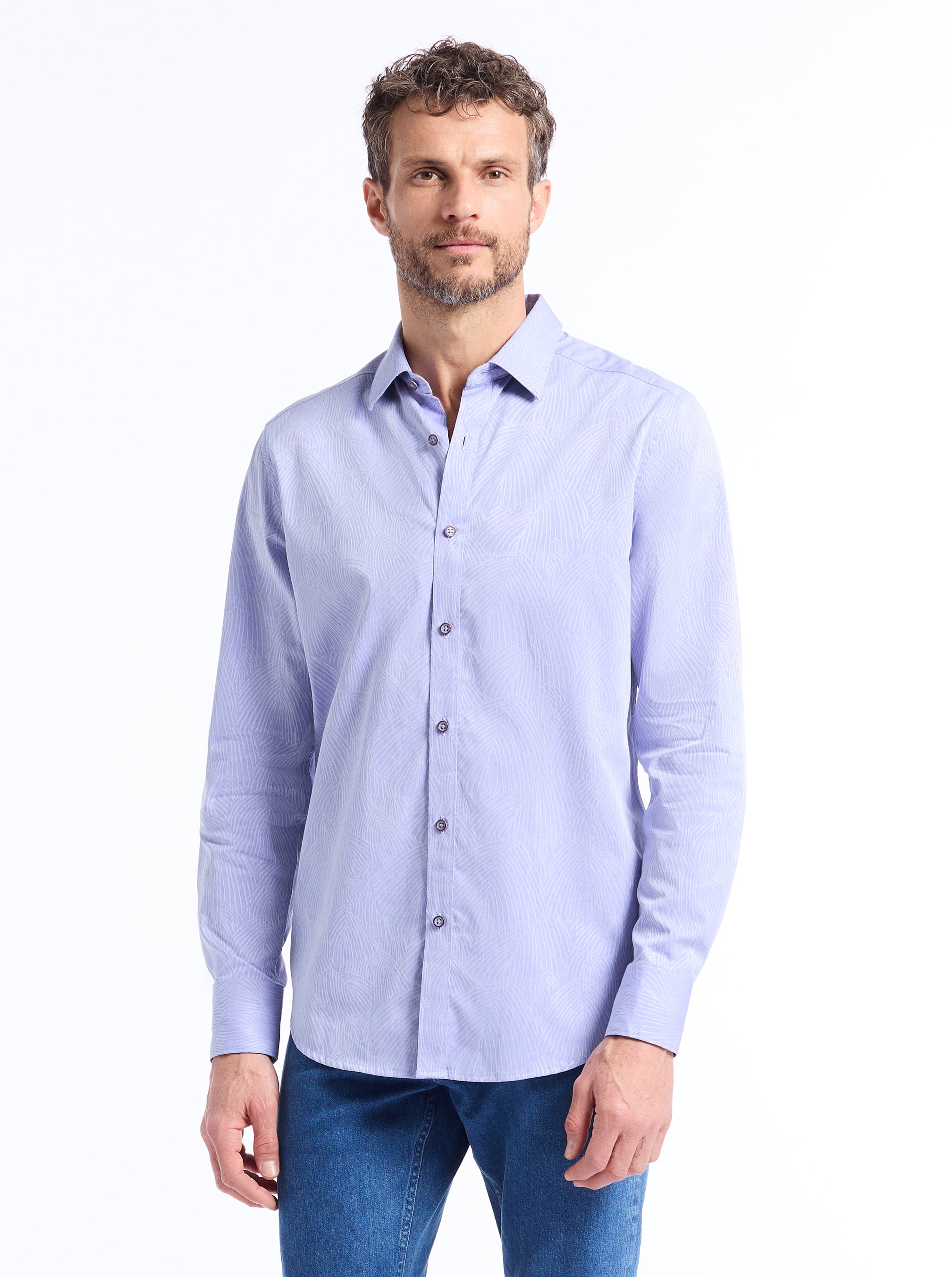 Man wearing a light blue button-up shirt and jeans on a white background