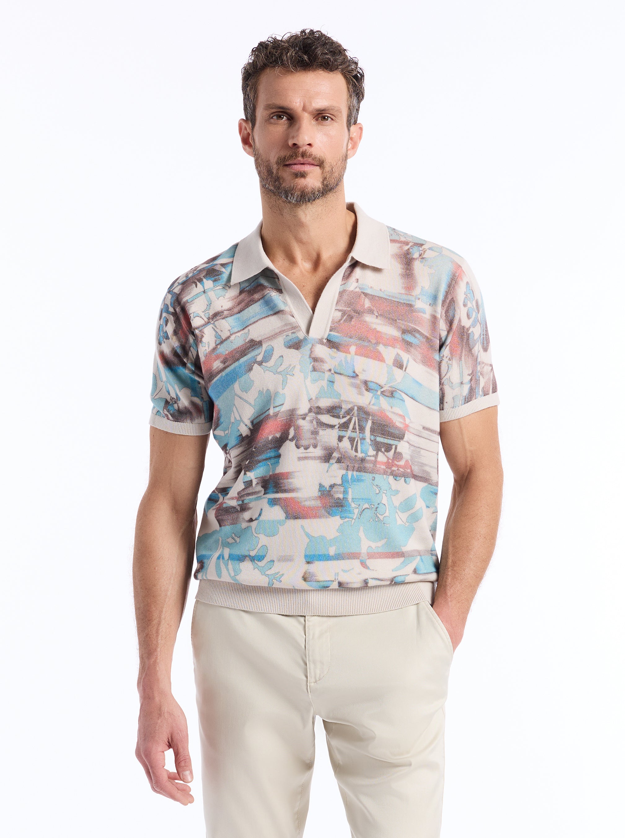 Man wearing a pastel watercolor patterned shirt with a white background