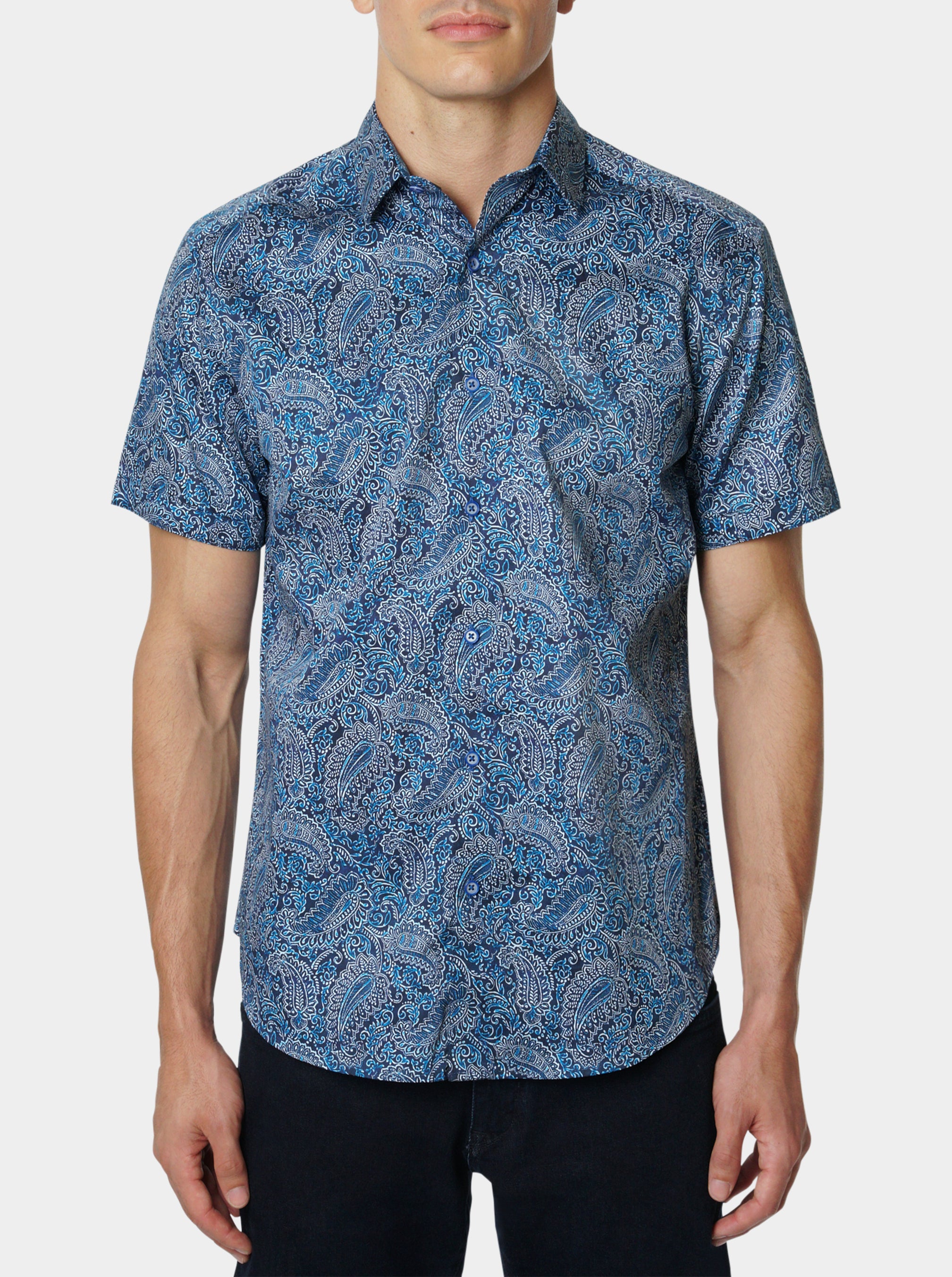 Man wearing a blue paisley patterned short sleeve shirt on a white background