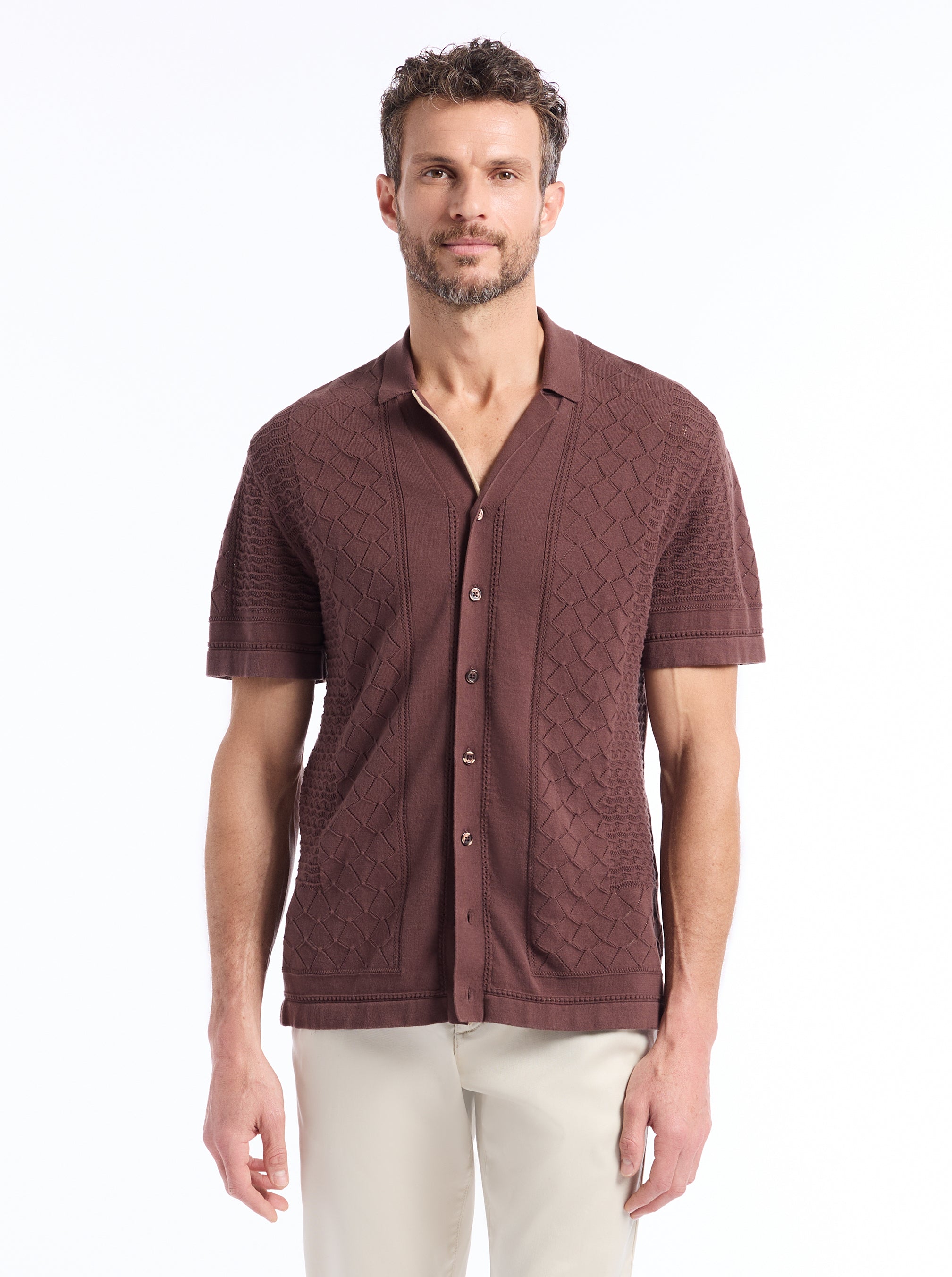 Man wearing a brown textured knit shirt on a white background