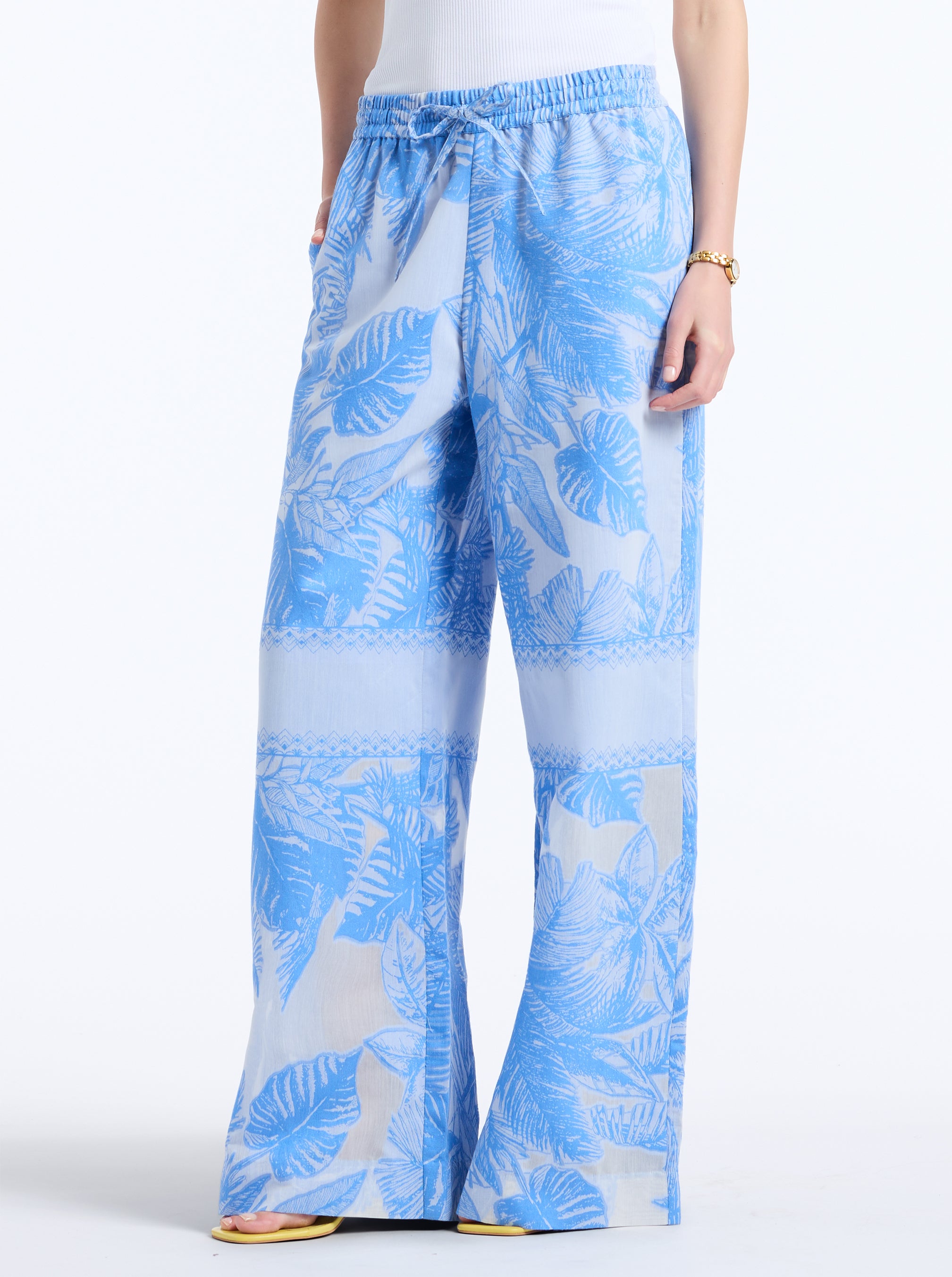 Blue and white leaf-patterned pants on a white background