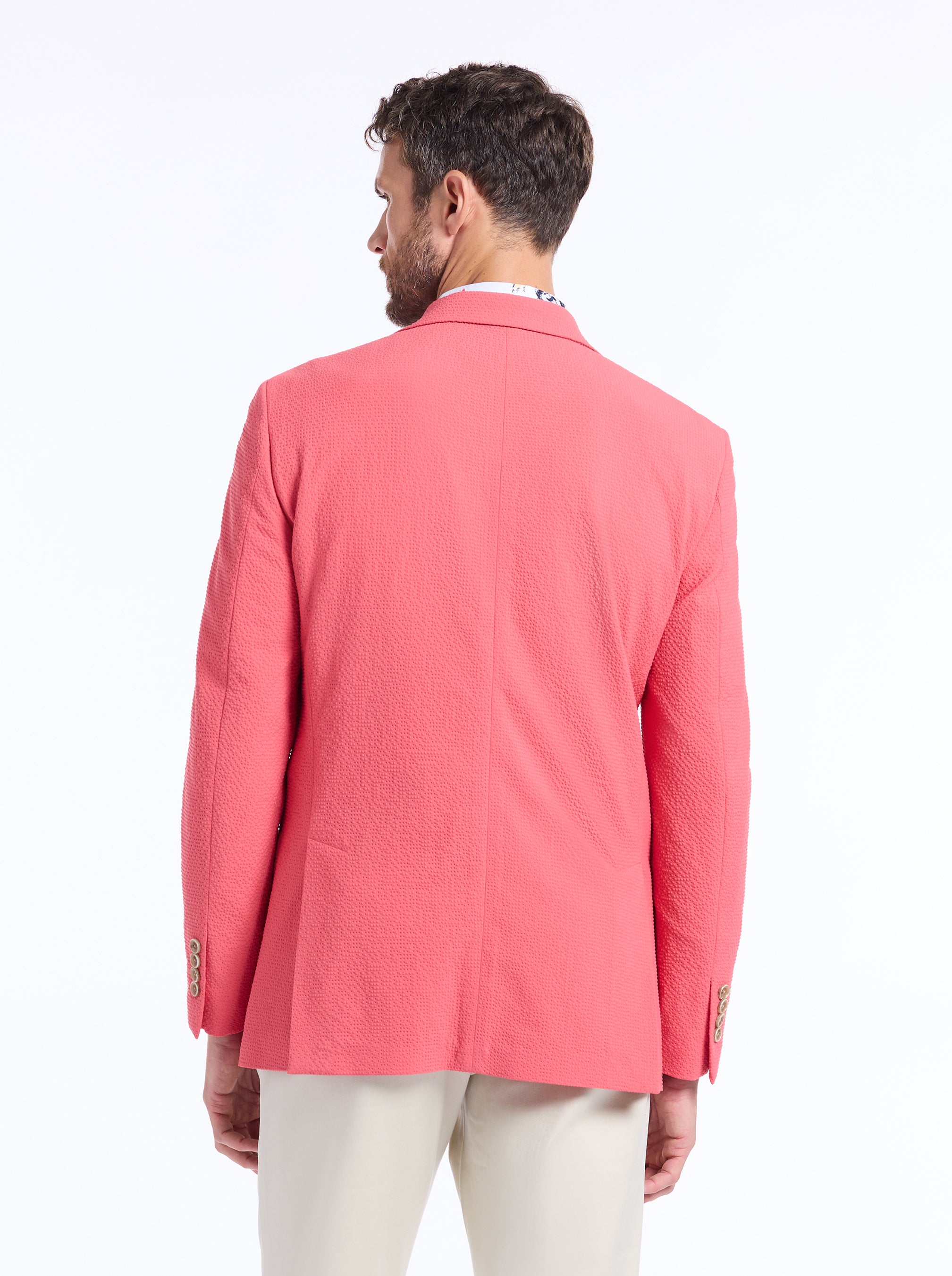 Man wearing a pink blazer on a white background