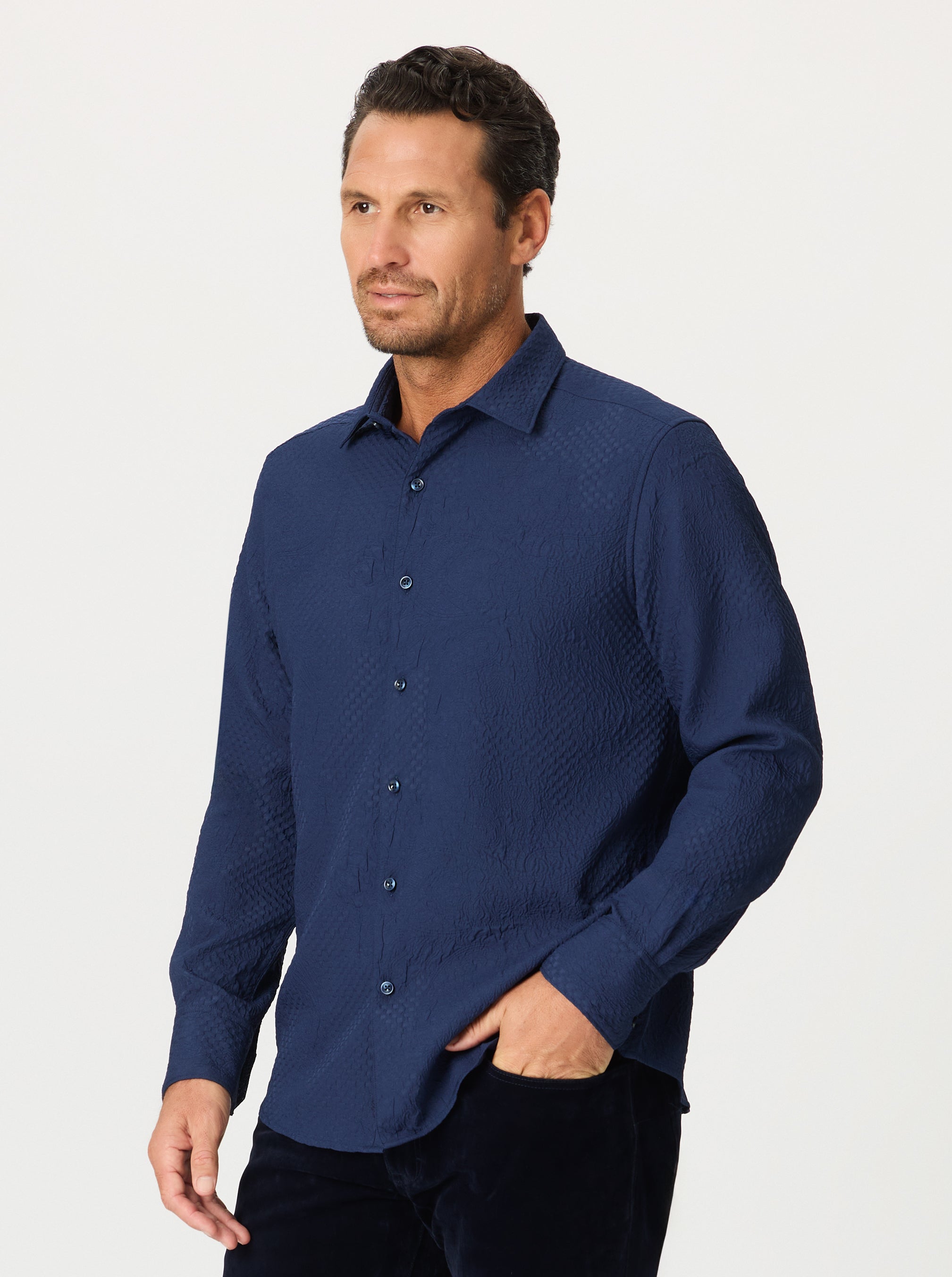 Man wearing a navy blue patterned shirt on a white background