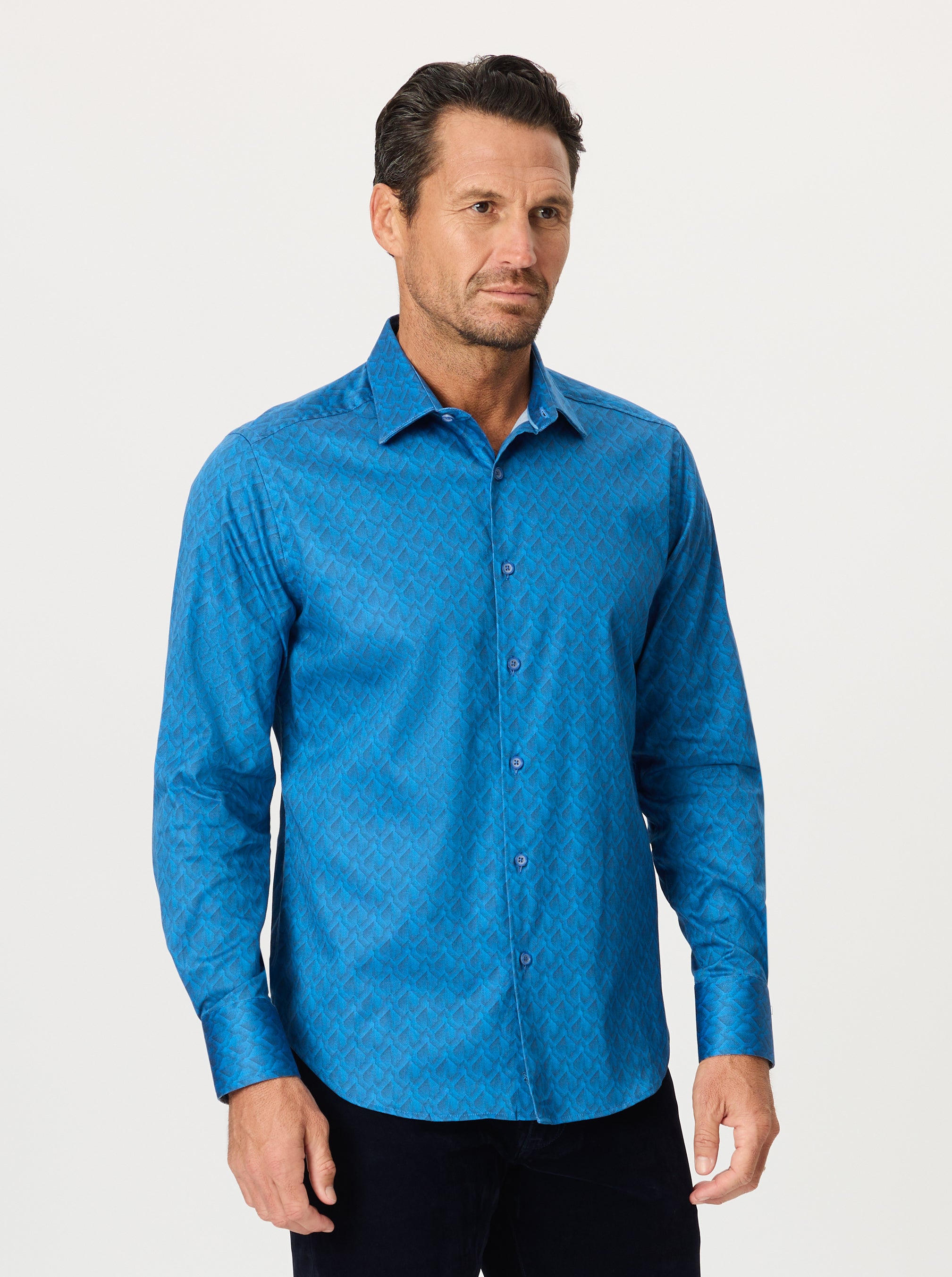 Man wearing a blue geometric patterned shirt against a white background