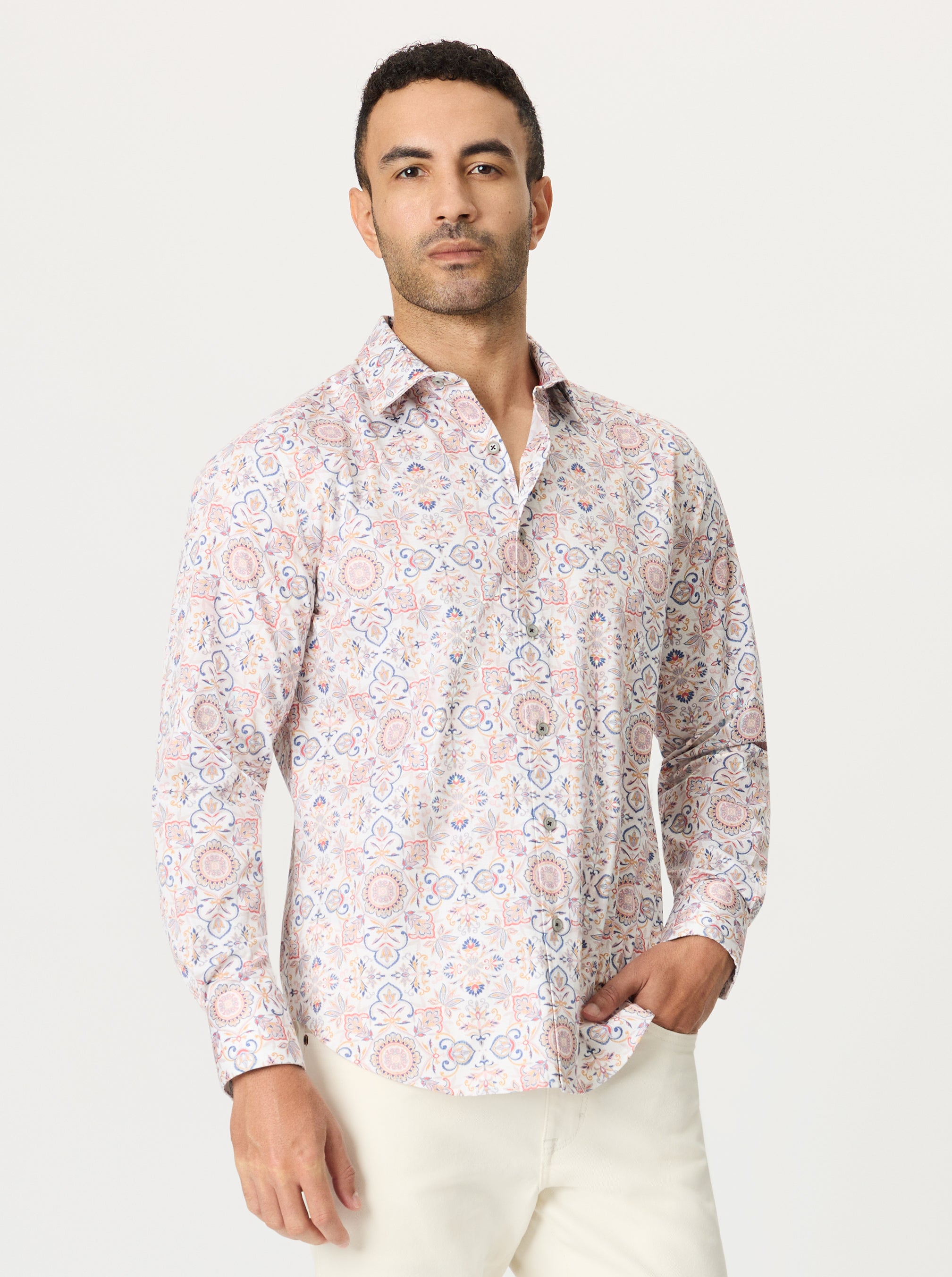 Man wearing a geometric floral medallion patterned shirt on a white background