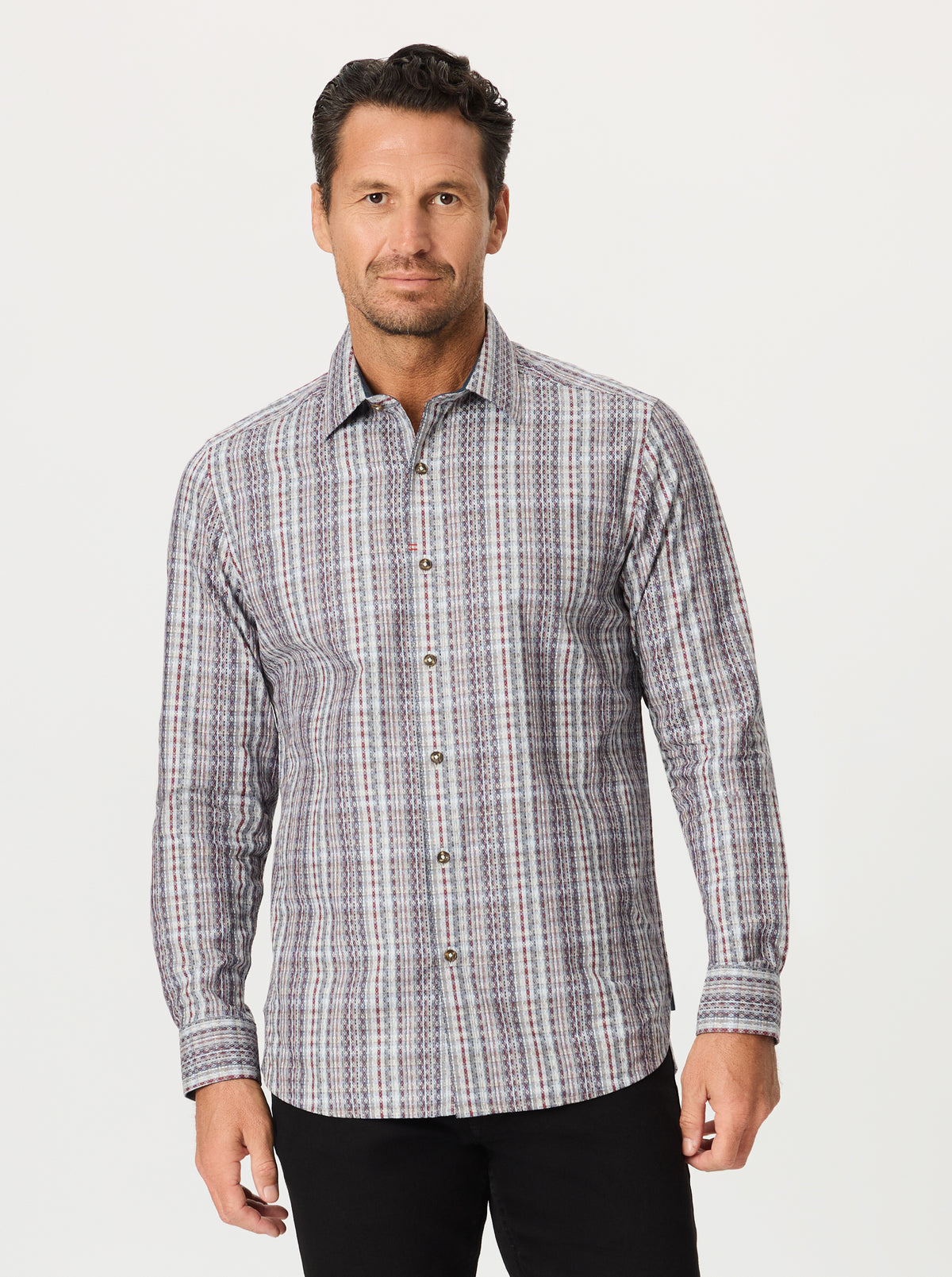 Man wearing a patterned shirt on a plain background