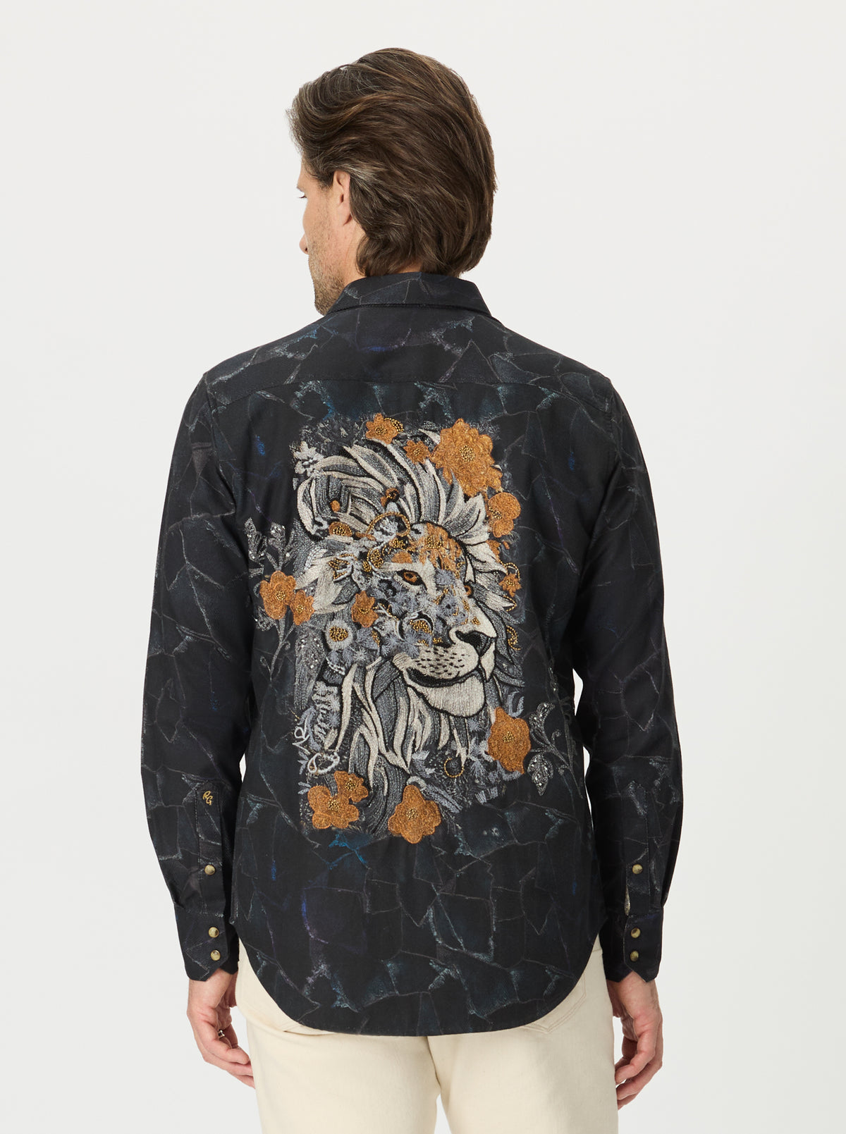 Man wearing a black shirt with a colorful lion design on the back against a white background