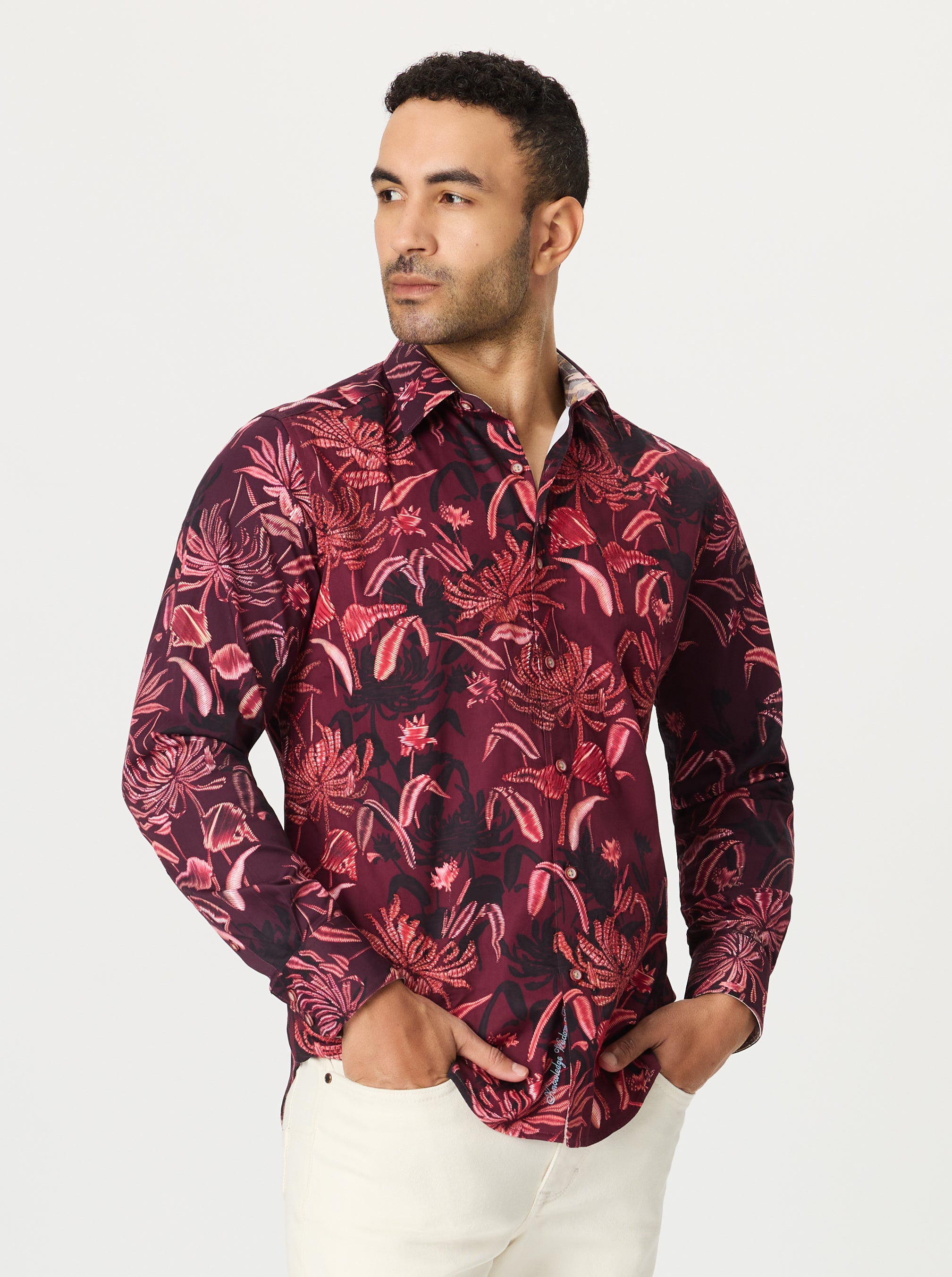 Man wearing a red floral patterned shirt on a white background