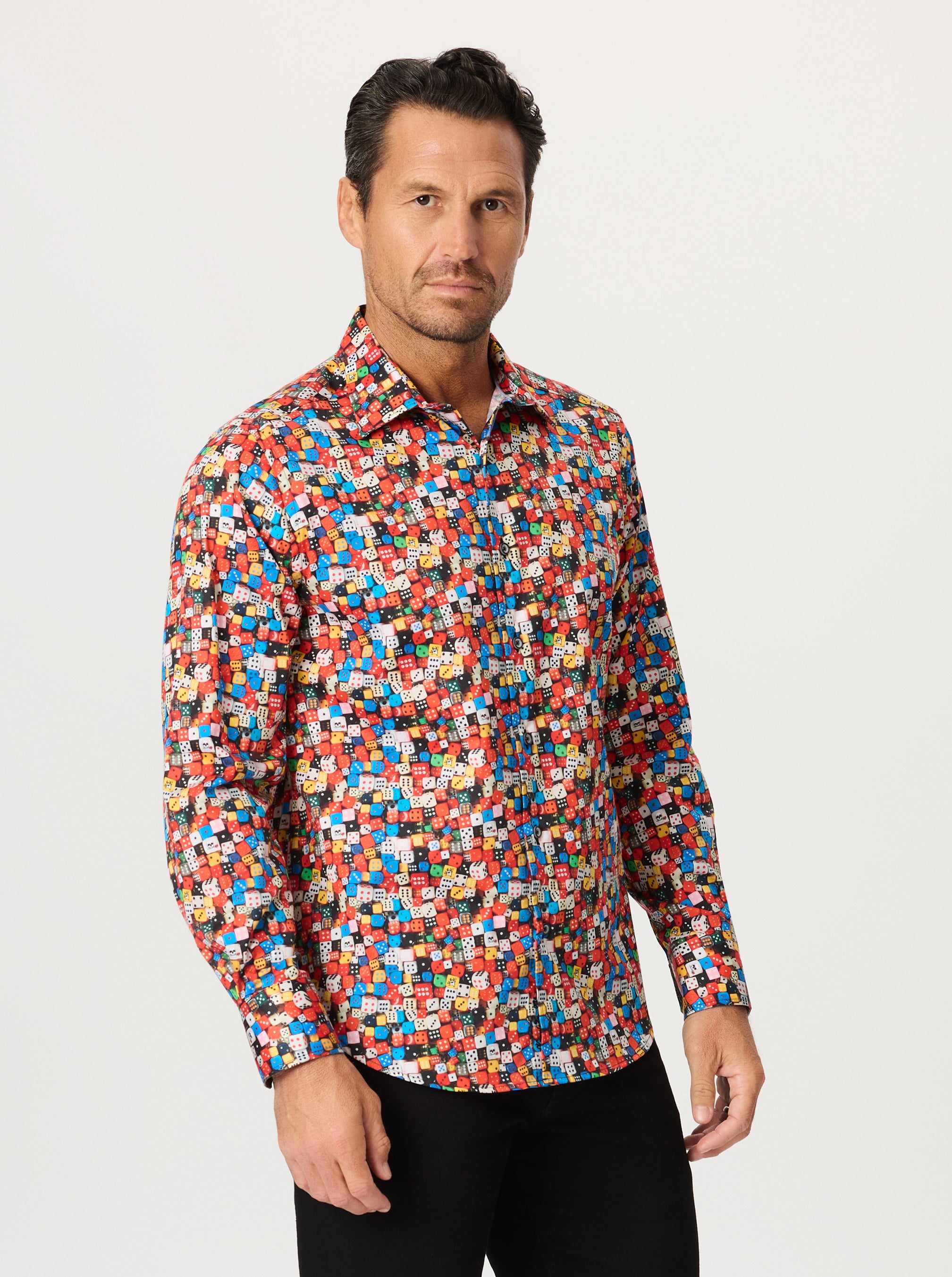 Man wearing a colorful dice patterned shirt against a white background