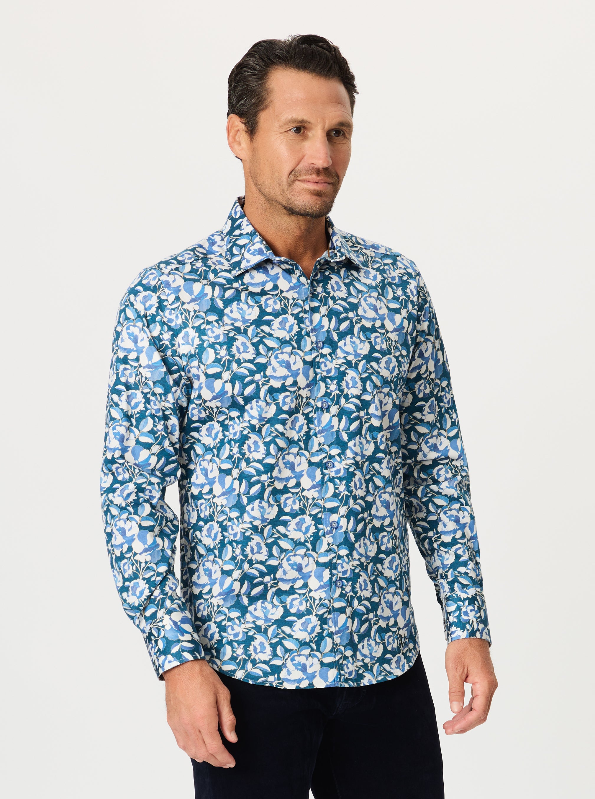 Man wearing a blue floral patterned shirt on a white background