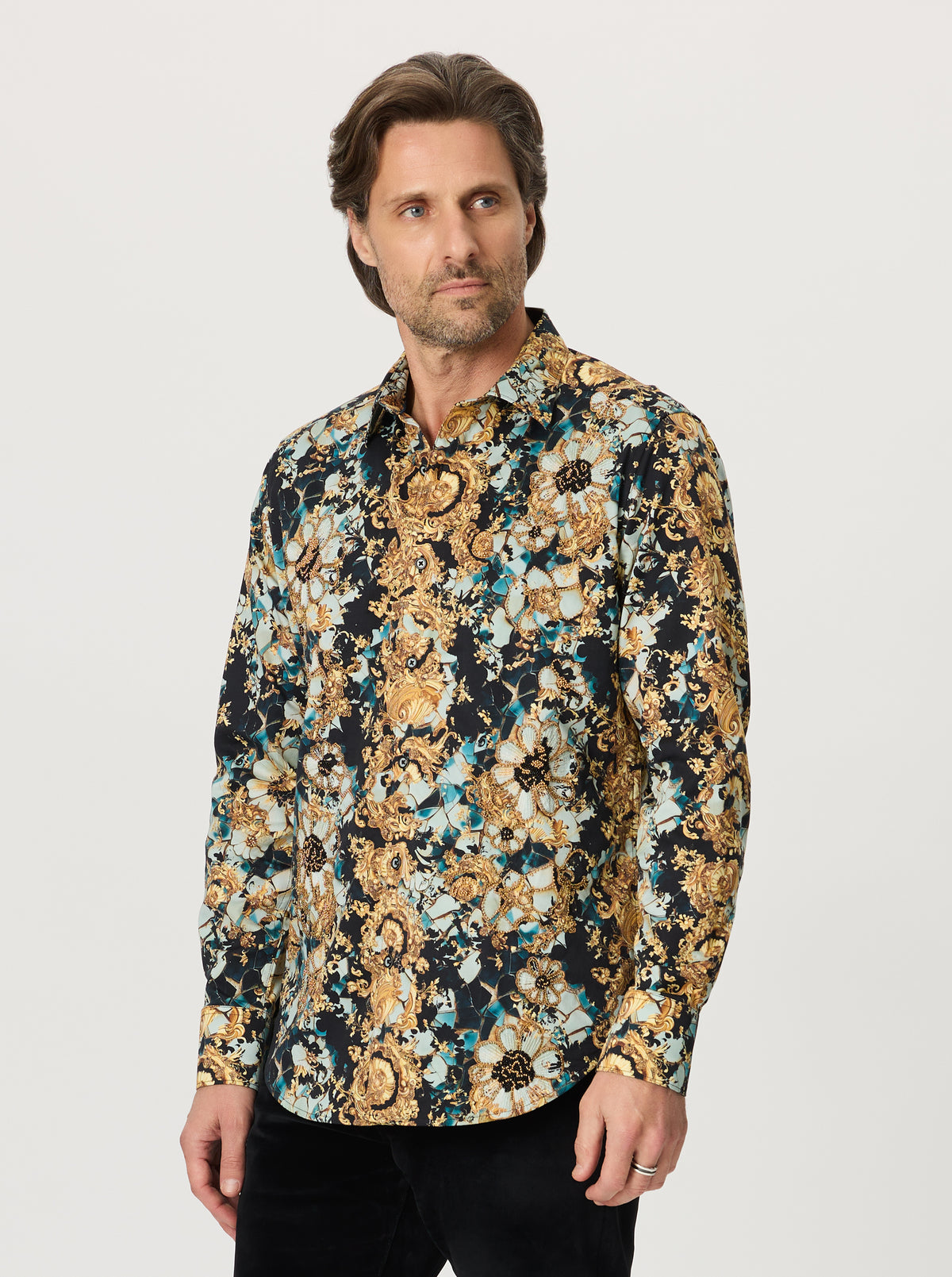 Man wearing a patterned shirt with a neutral background