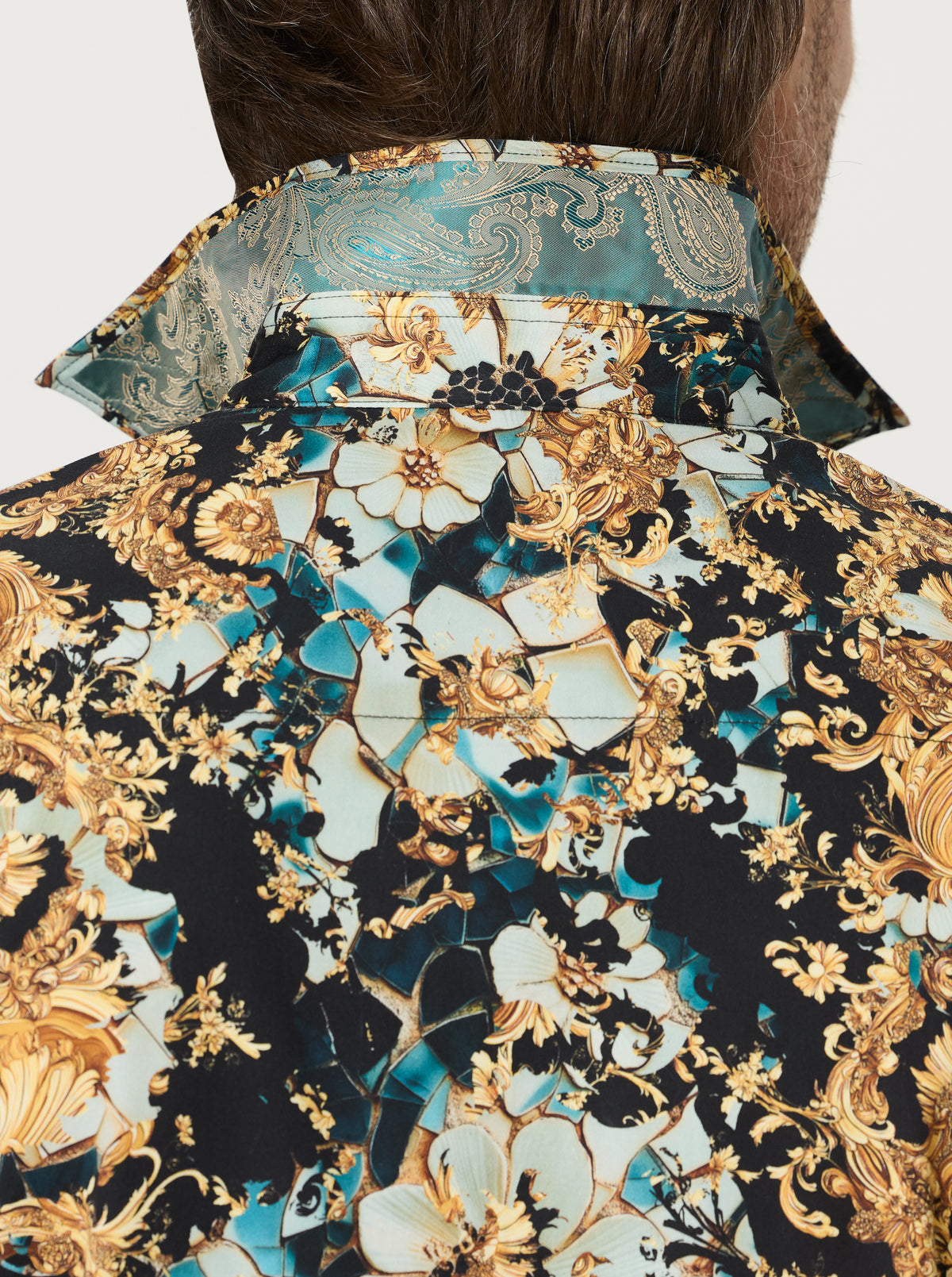 Close-up of a person wearing a patterned shirt with intricate designs.