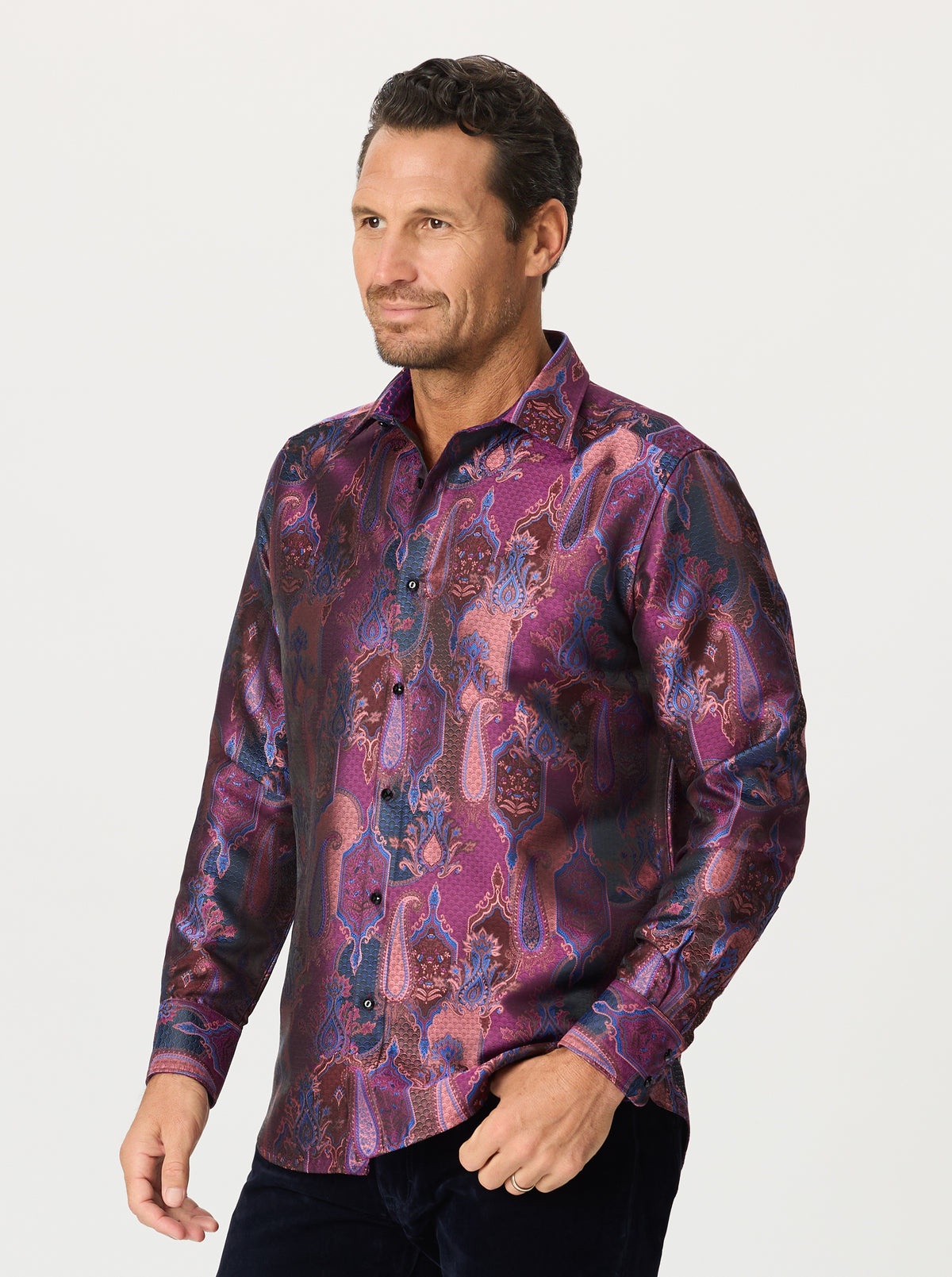 Man wearing a silk purple patterned shirt on a white background