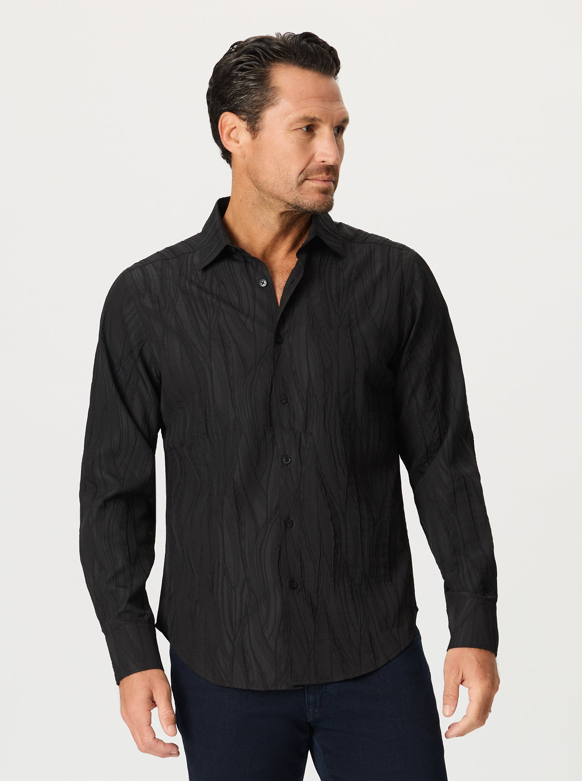 Man wearing a textured black button-up shirt against a white background