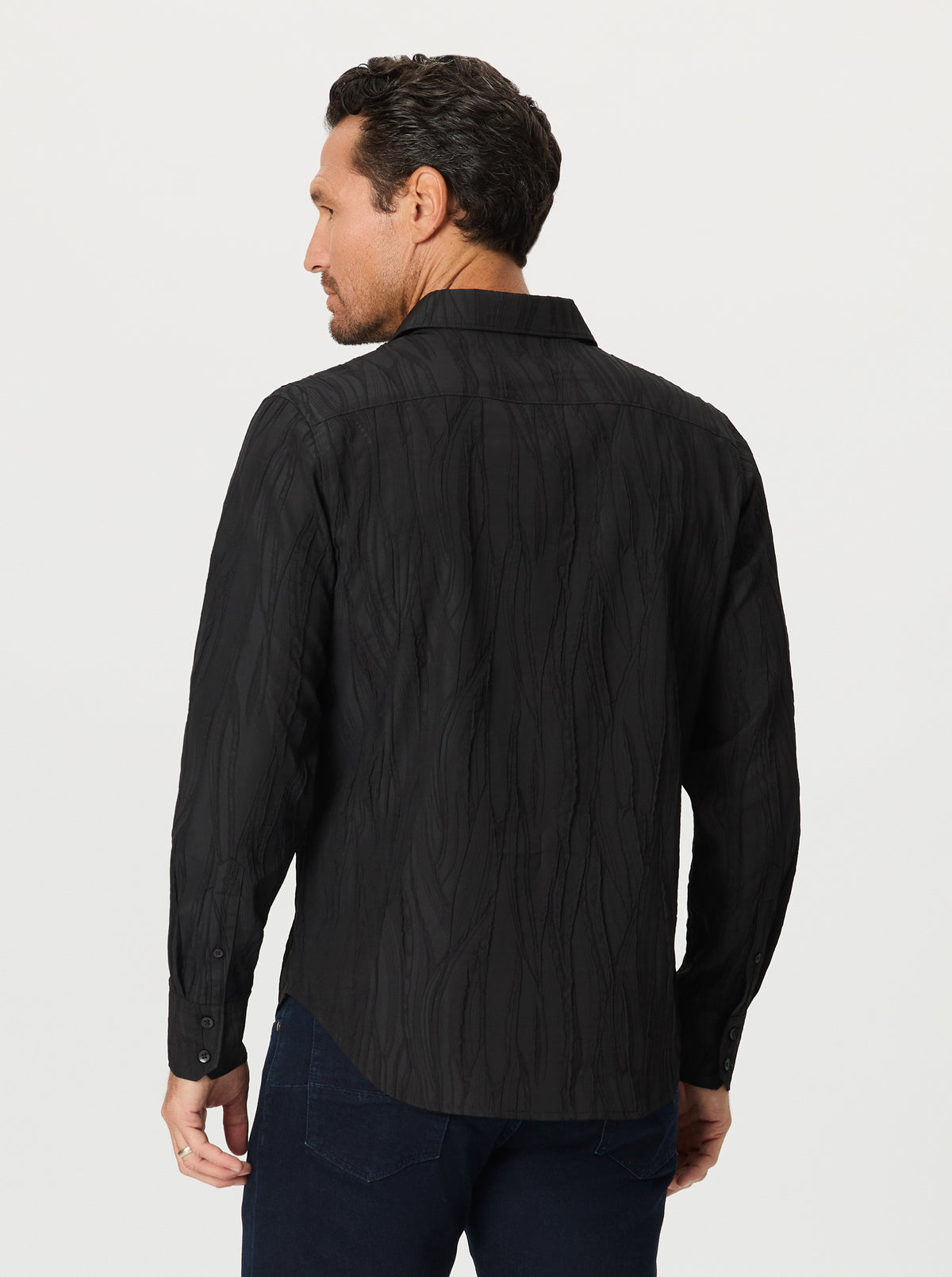 Man wearing a black jacquard textured shirt on a light gray background