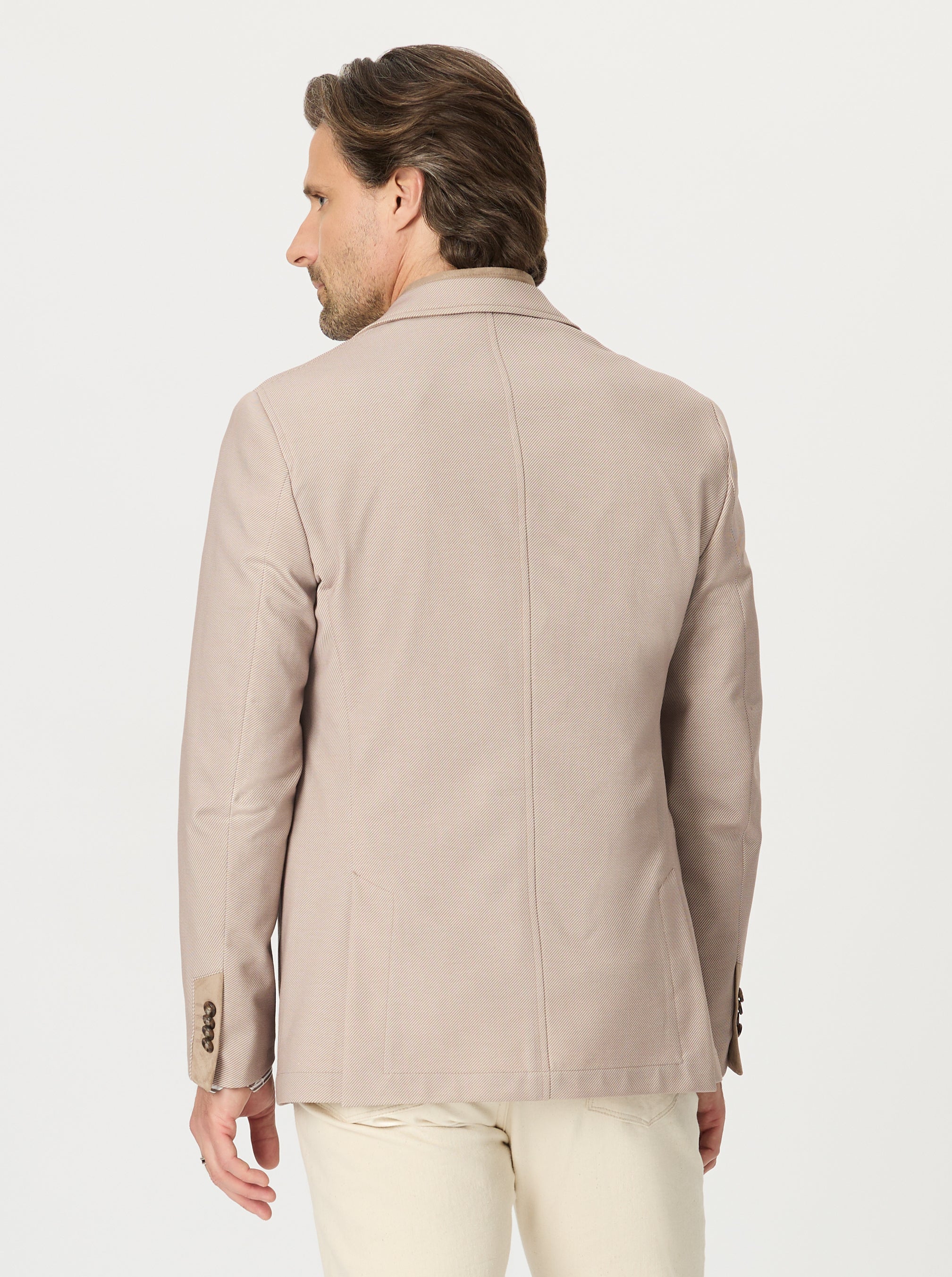 Man wearing a beige blazer on a white background