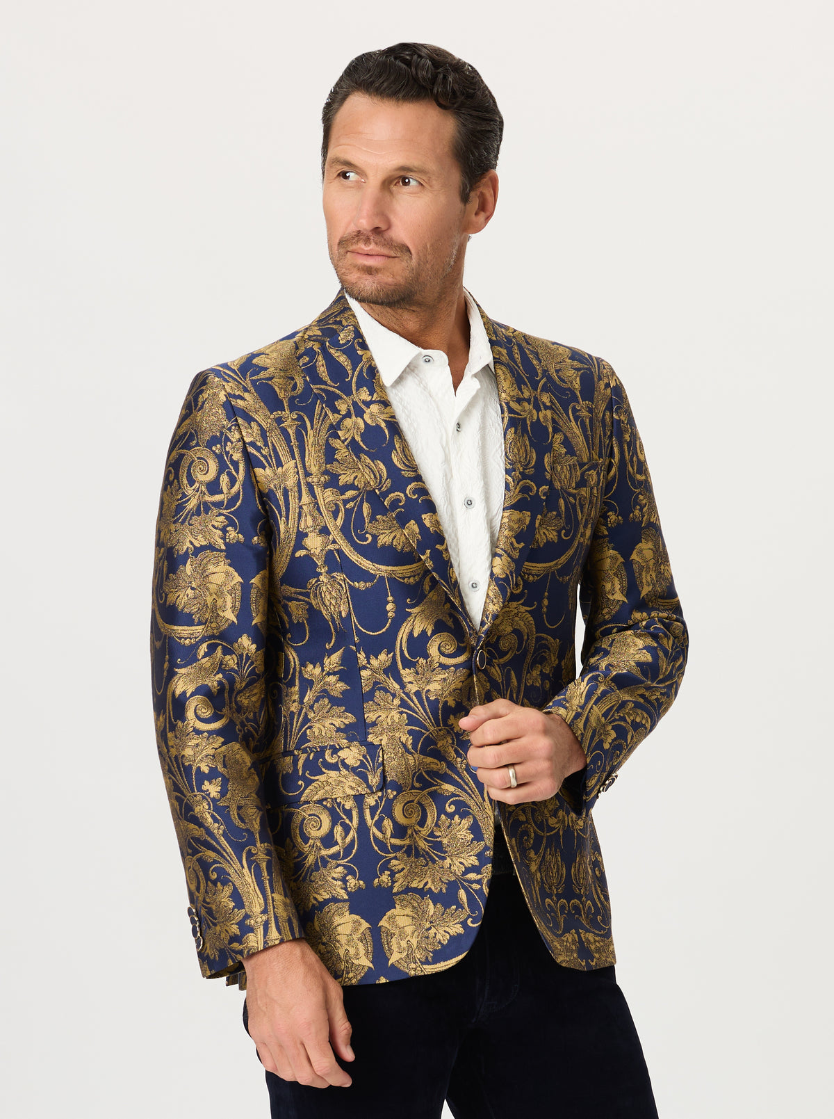 Man wearing a patterned blazer with a white shirt on a light gray background
