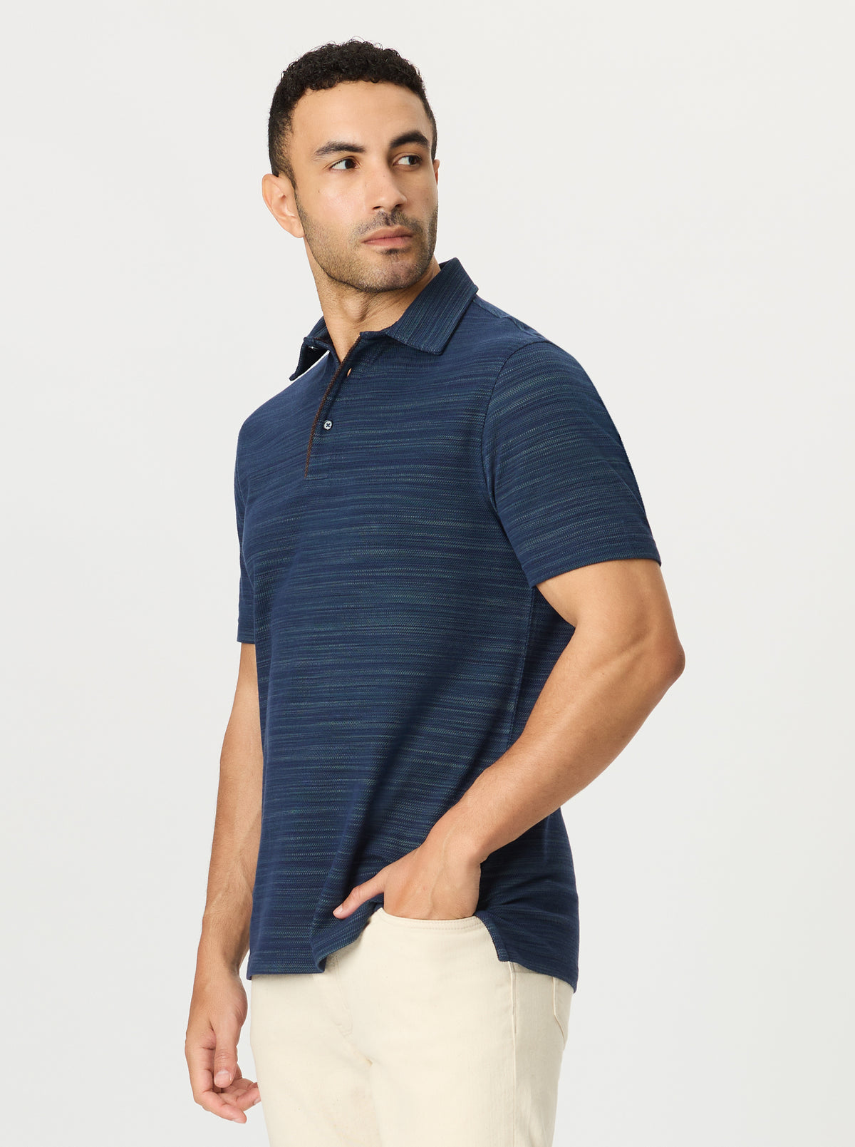 Man wearing a blue striped polo shirt on a light gray background