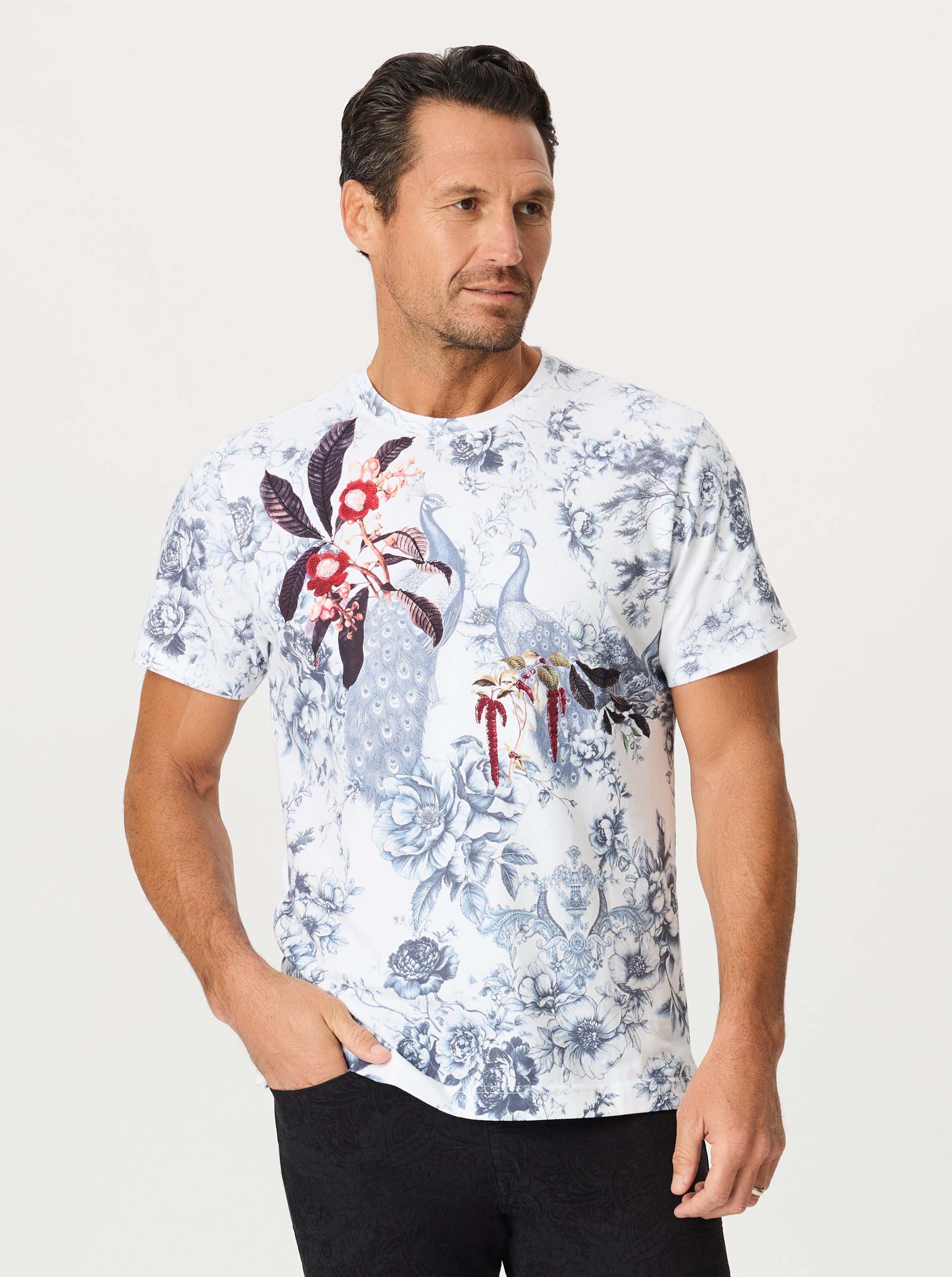 Man wearing a floral-patterned t-shirt on a white background