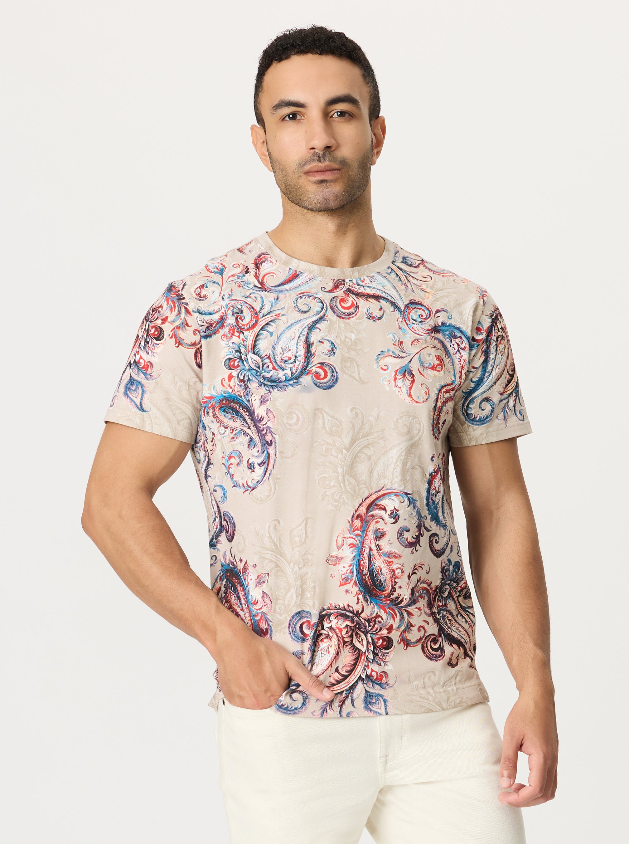 Man wearing a paisley patterned t-shirt on a plain background