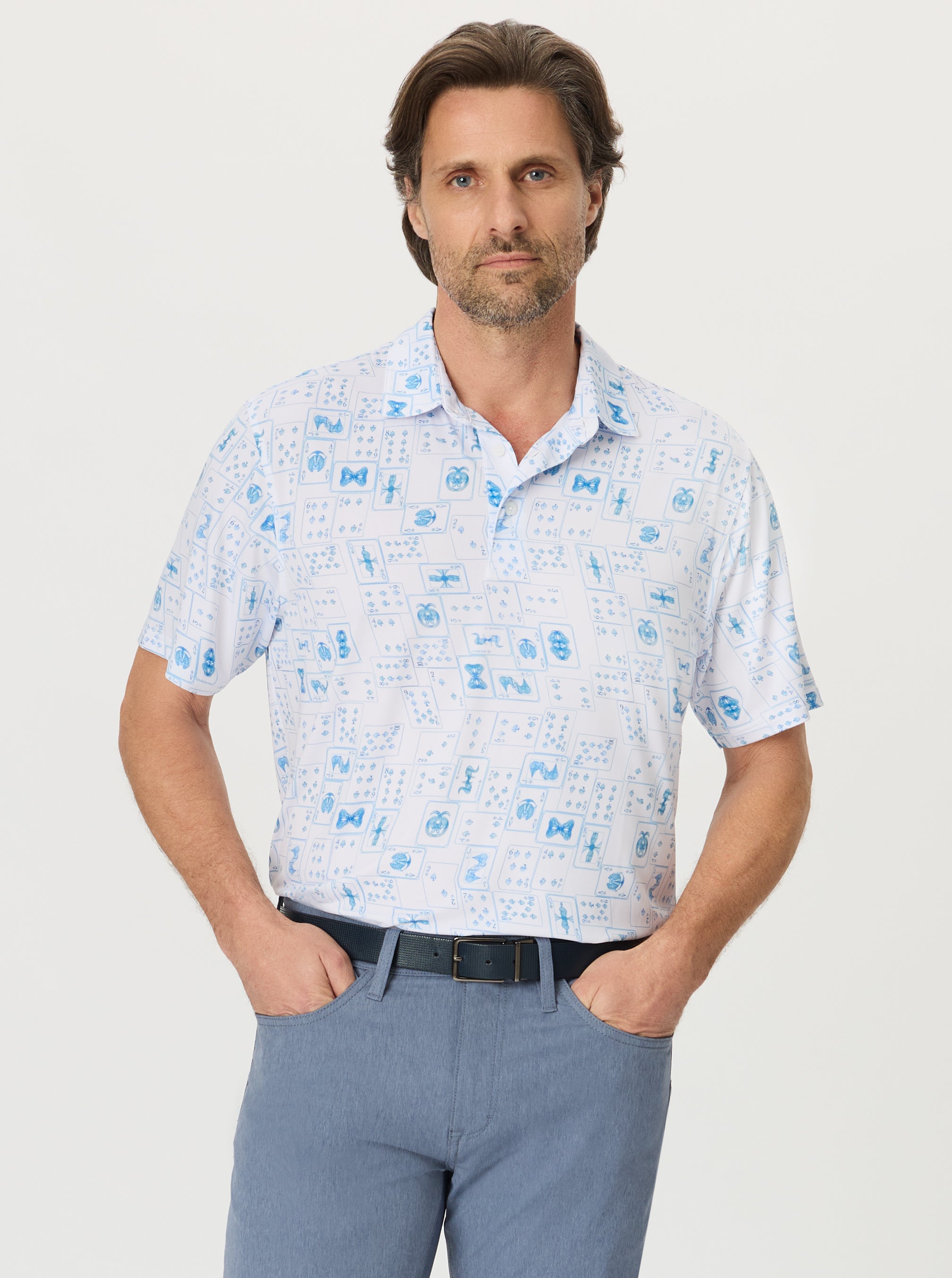 Man wearing a white short-sleeve shirt with blue patterns on a light gray background