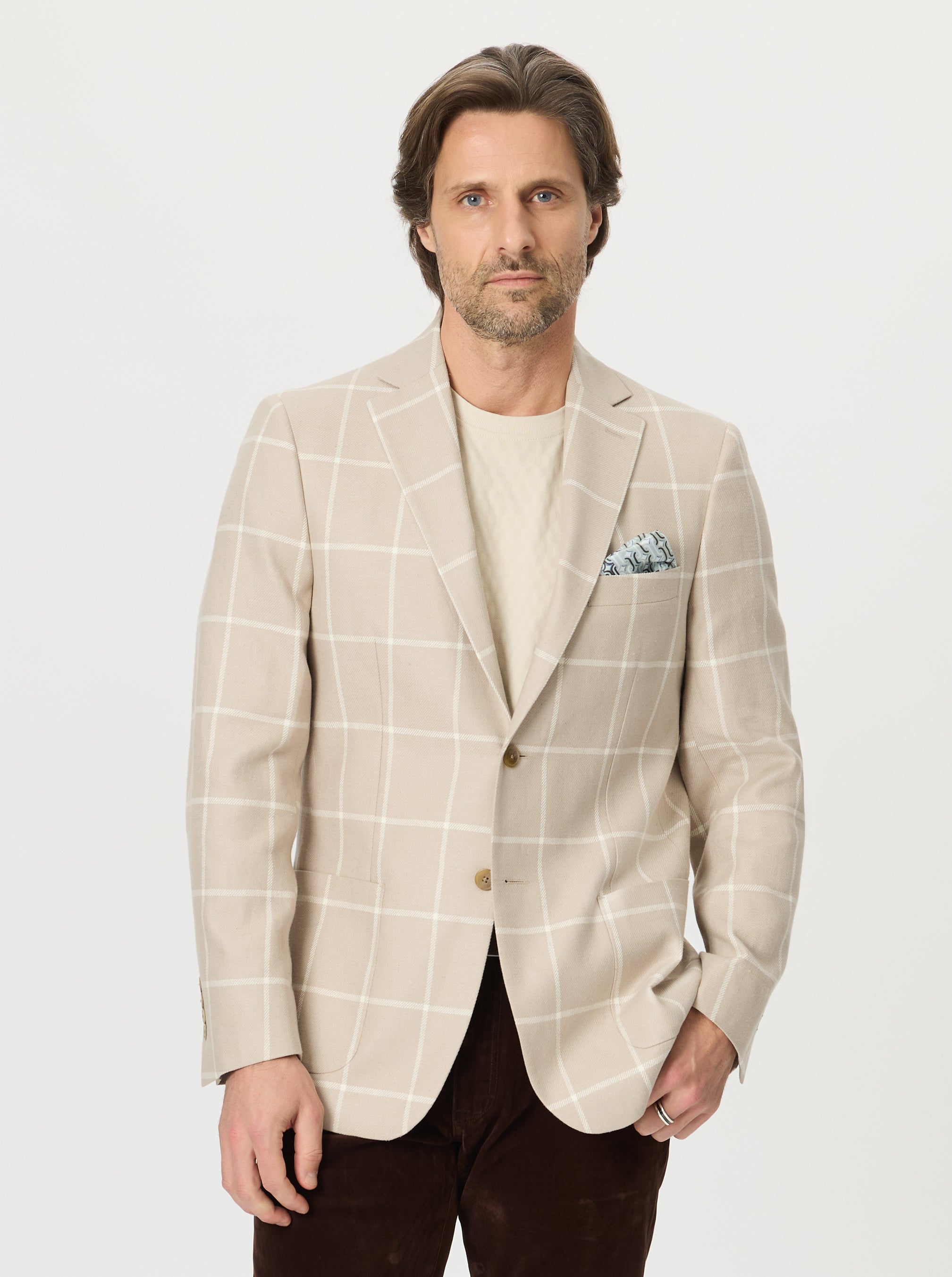 Man wearing a beige checkered blazer on a white background
