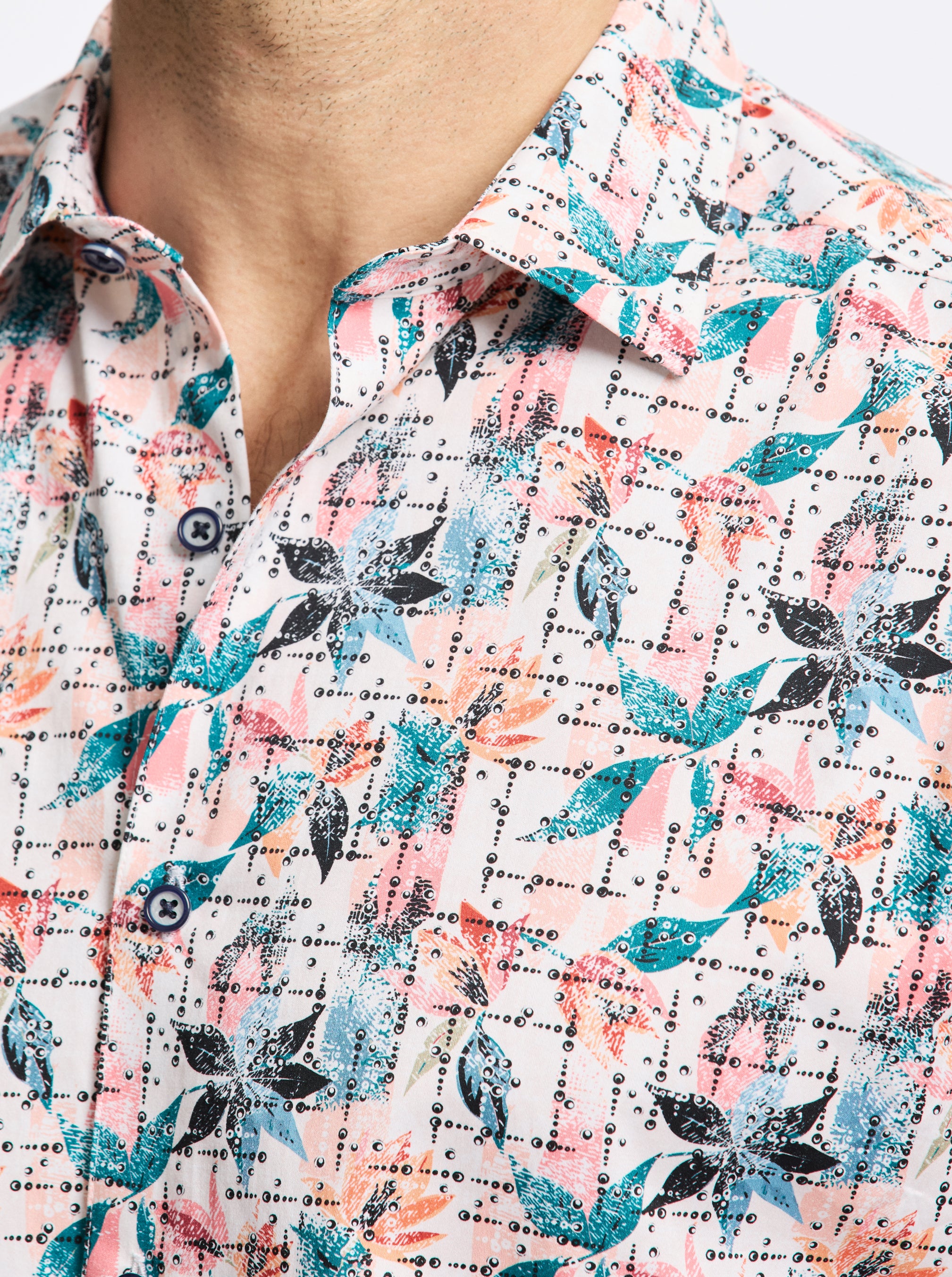 Close-up of a patterned shirt with blue, pink, and black design on a white background