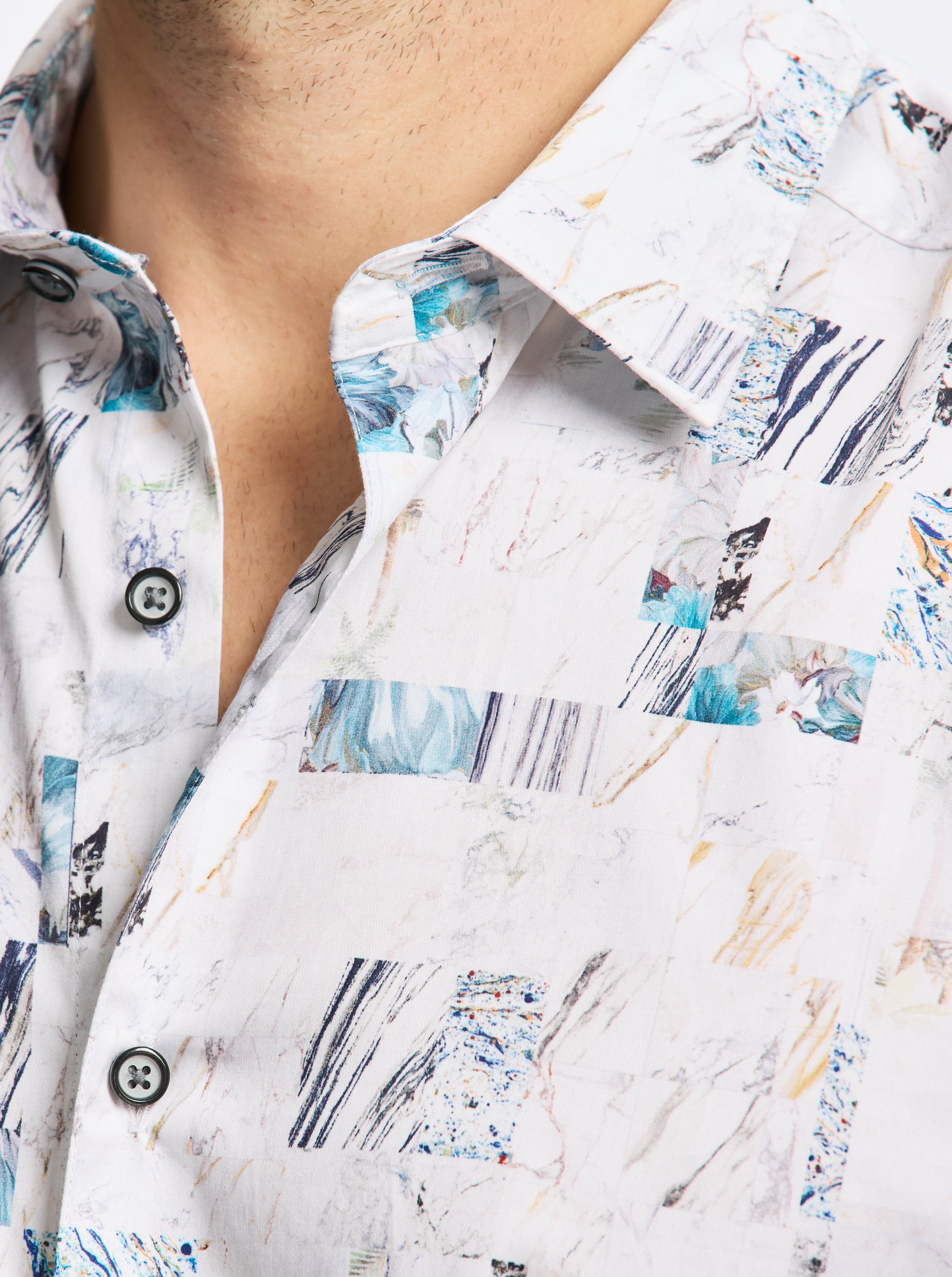 Close-up of a person wearing a white shirt with abstract blue and black patterns.