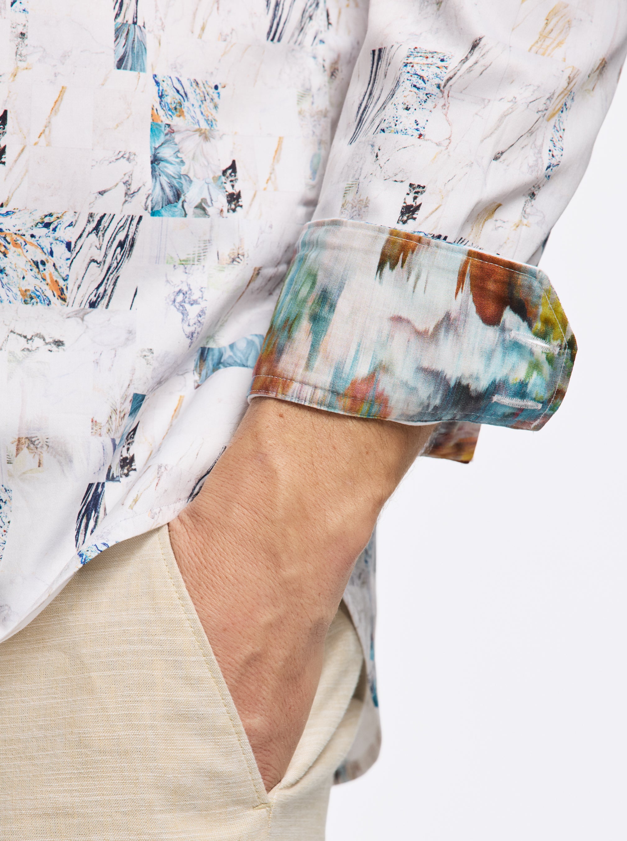 Close-up of a person wearing a colorful patterned shirt with rolled-up sleeves on a white background