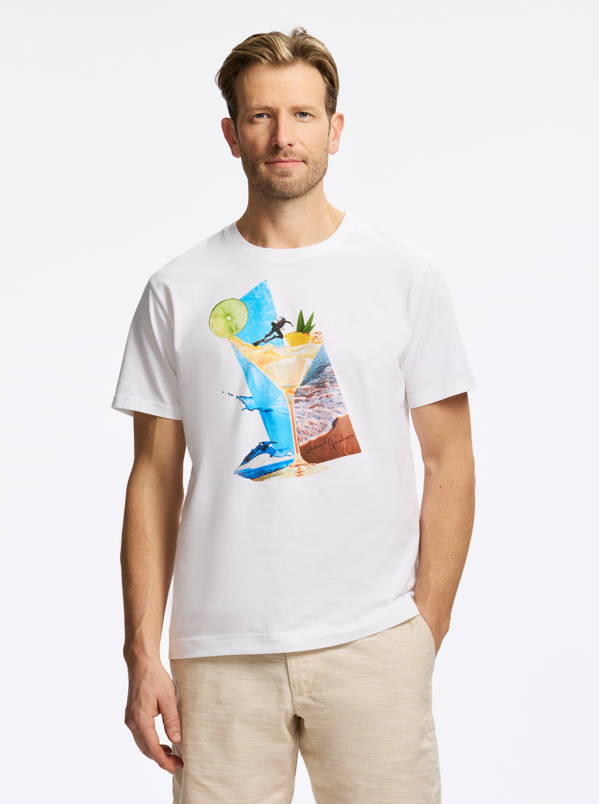 Man wearing a white t-shirt with a colorful drink and beach graphic design on a white background