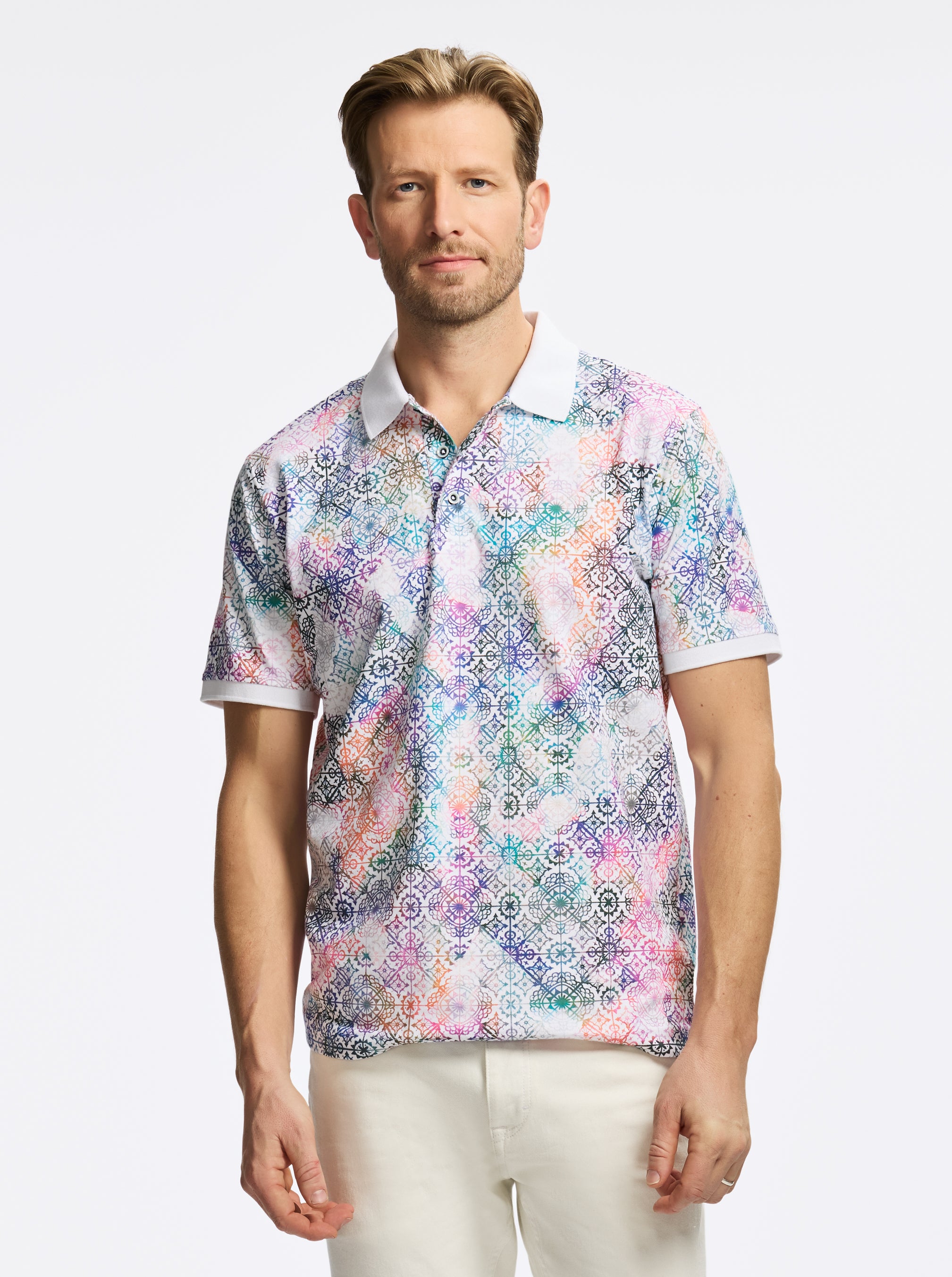 Man wearing a colorful patterned shirt on a white background
